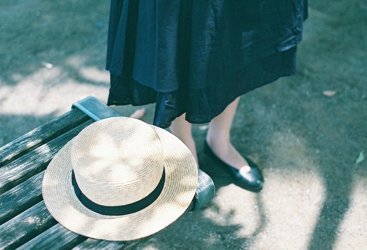 moment de pause en extérieur avec une personne assise sur un banc et un chapeau de paille