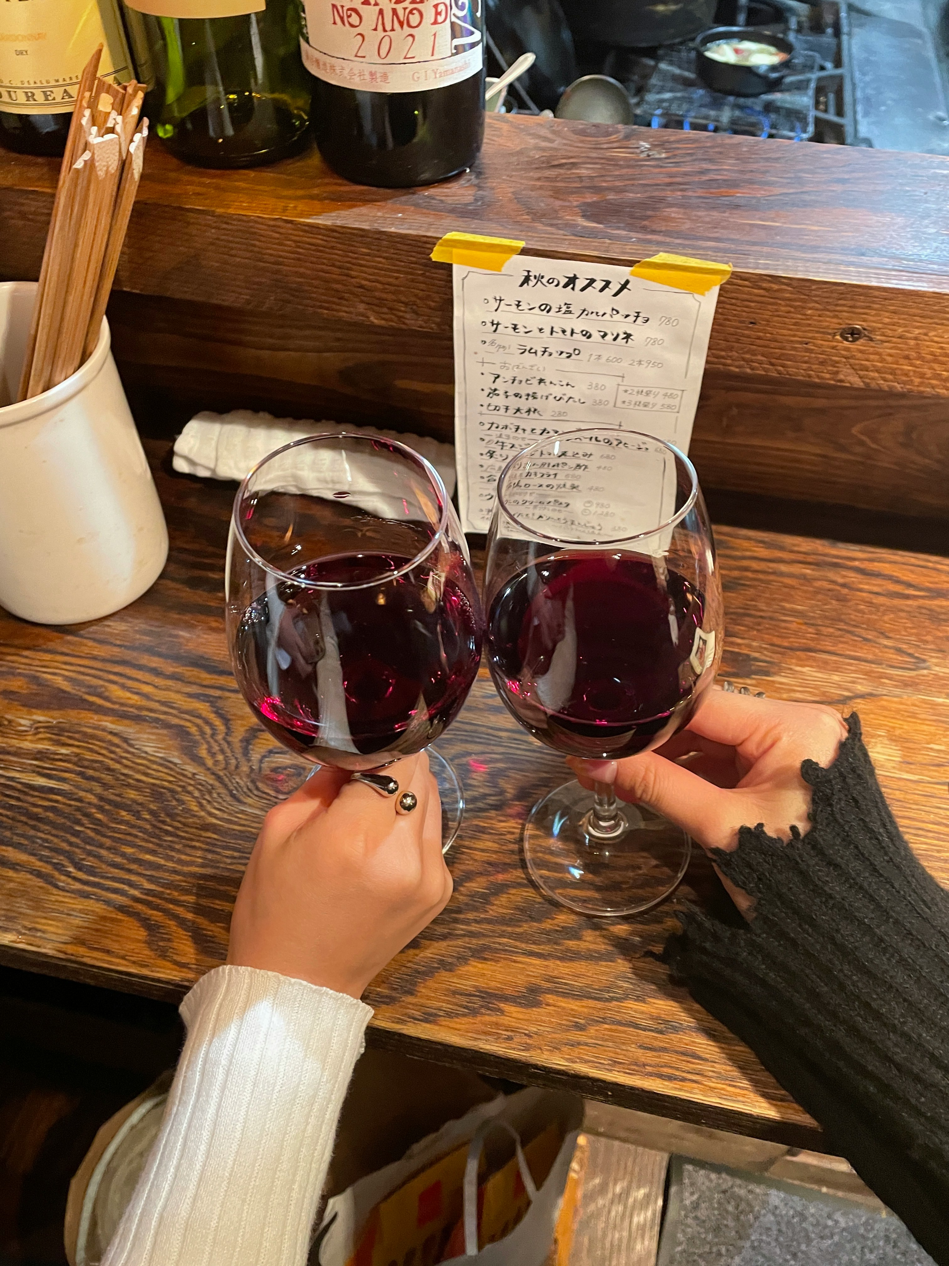 Bicchieri di vino rosso su un bancone di legno con un biglietto scritto a mano