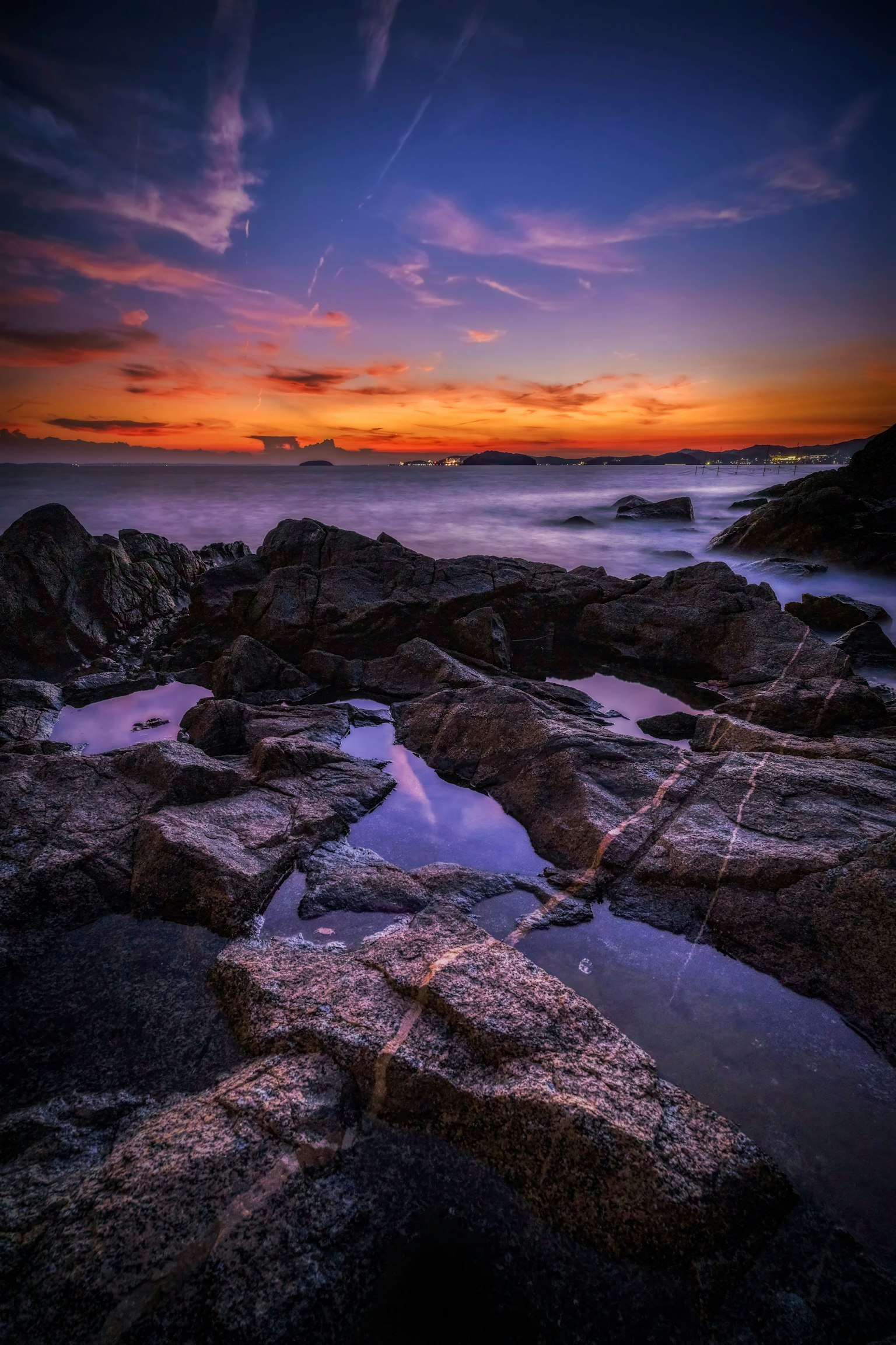 Rocas costeras con charcas durante un vibrante atardecer