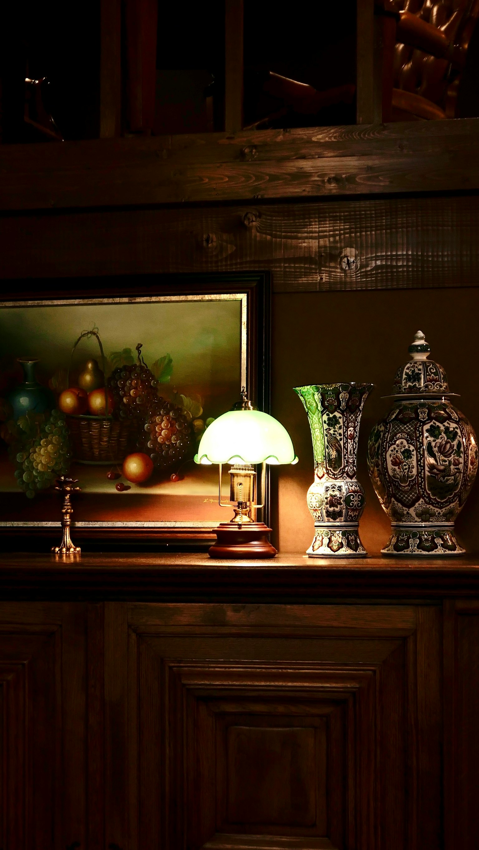 木製の棚の上に置かれたランプと花瓶のある静かなインテリアシーン