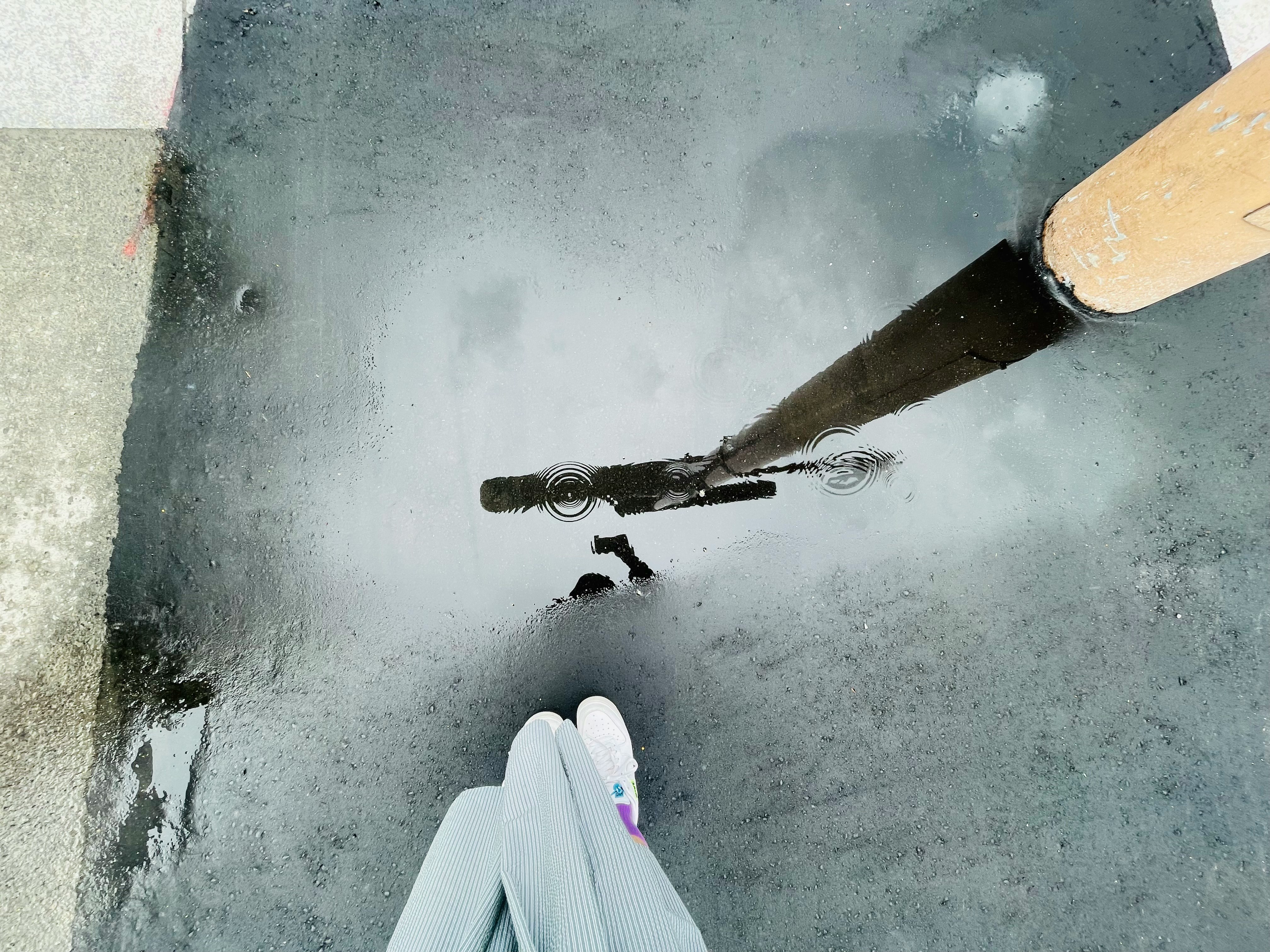 Water splashing in a puddle on a rainy day, wet pavement
