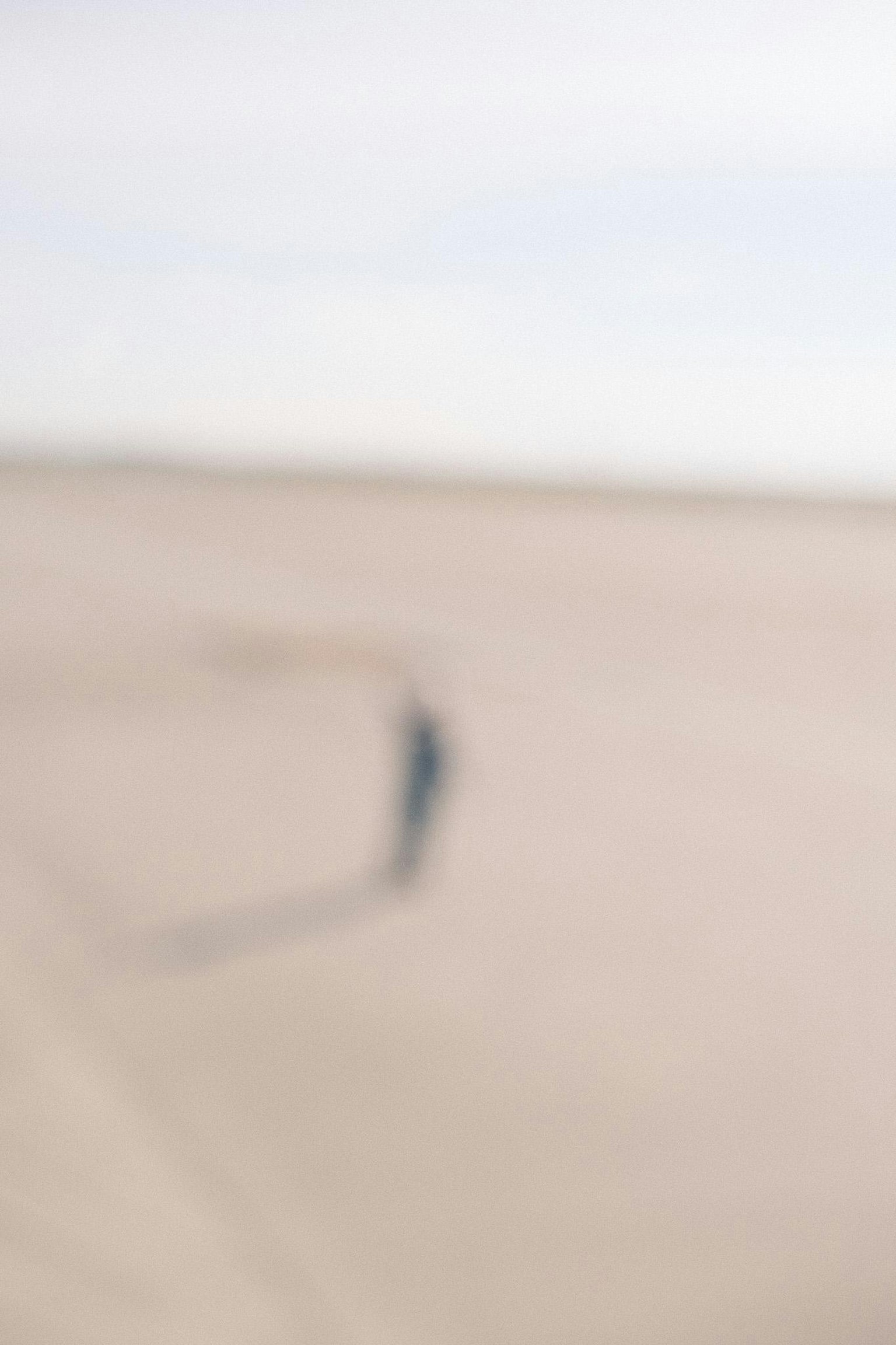 A blurred landscape featuring a figure casting a shadow