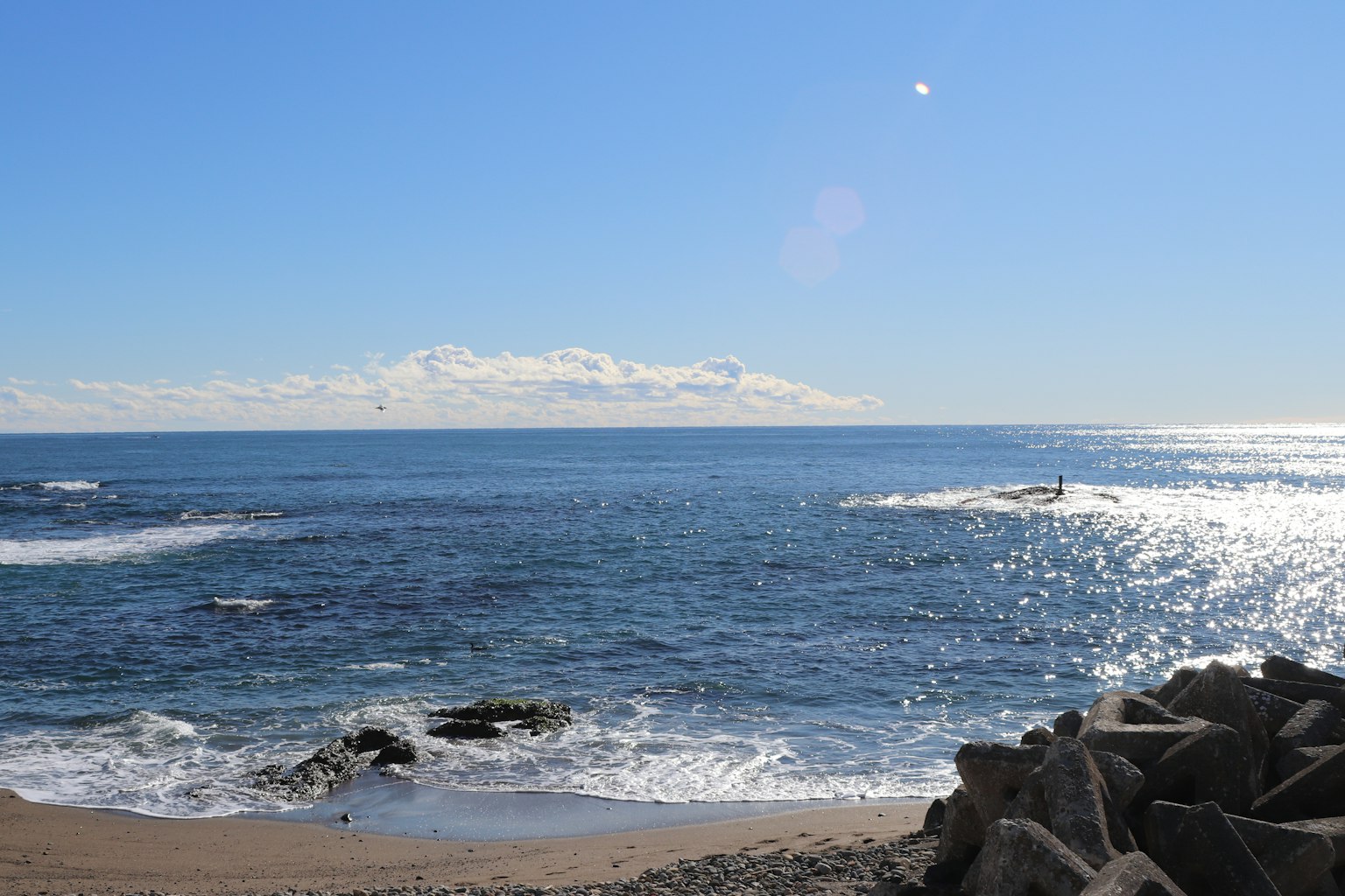 广阔的蓝色海洋和天空 岩石海岸与温和的波浪