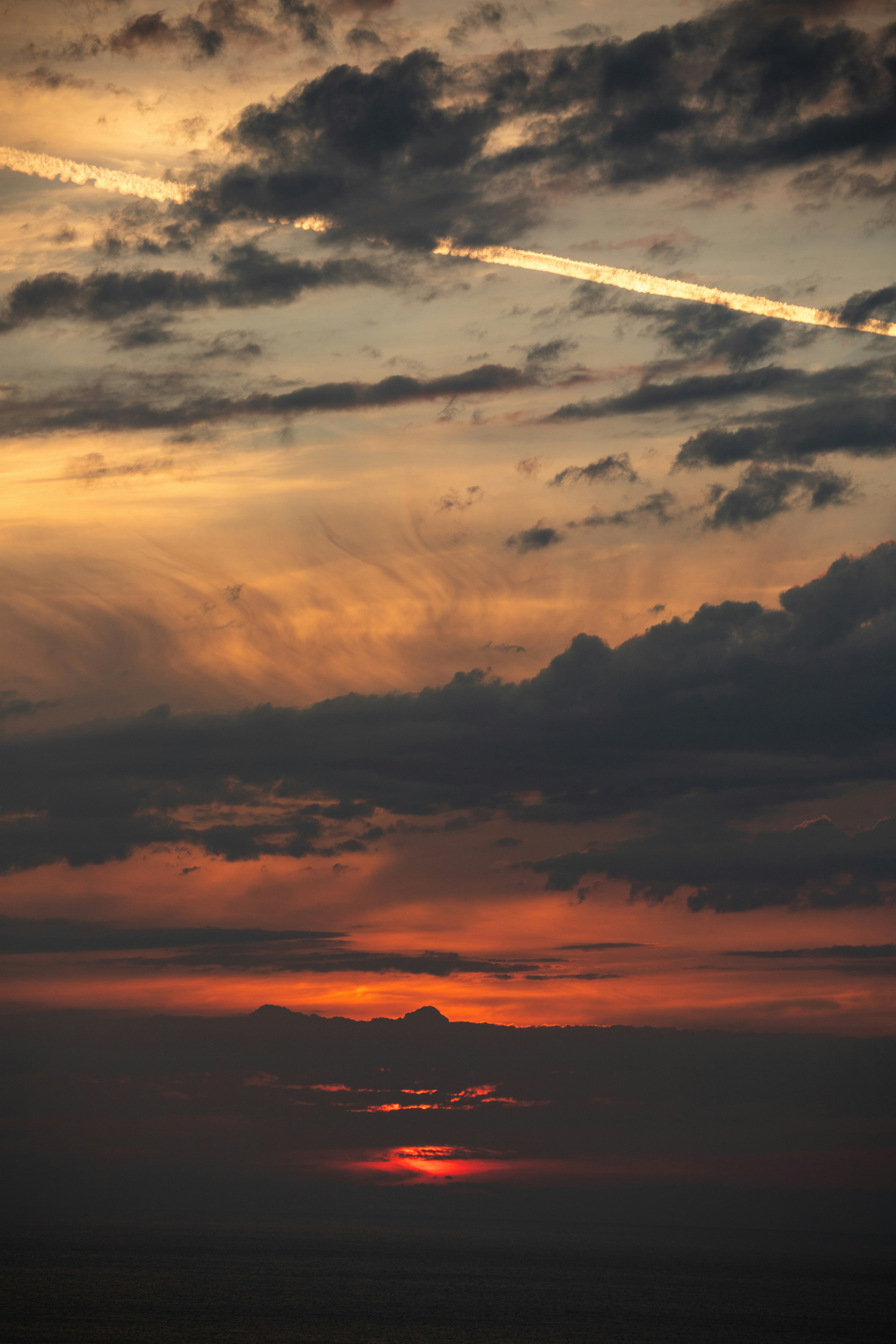 ciel de coucher de soleil avec nuages superposés et lueur orange chaude