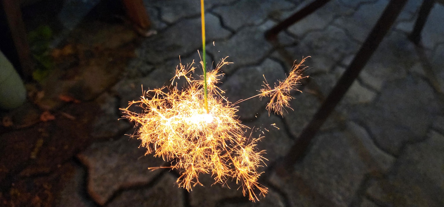 Sparkler emitting bright sparks against a dark background
