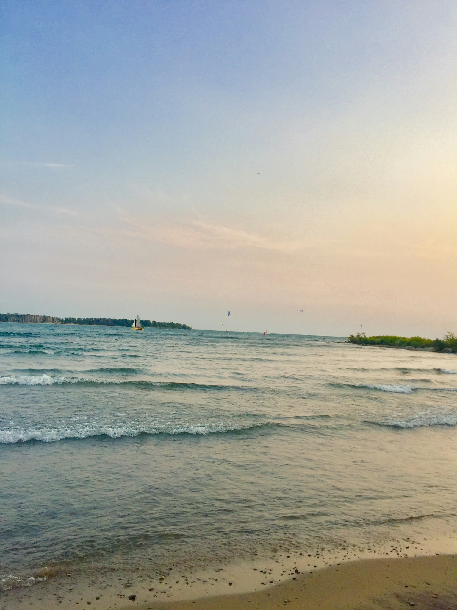 ทิวทัศน์ชายหาดที่สวยงามมีคลื่นเบาและท้องฟ้ายามพระอาทิตย์ตก