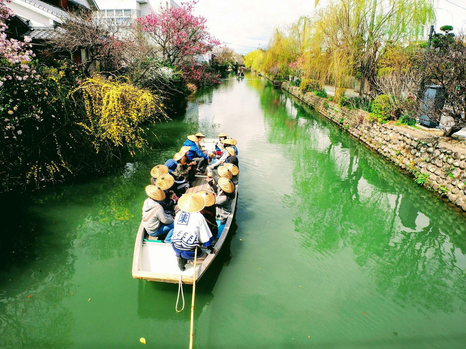 Vista panoramica di persone su una barca che navigano in un canale verdeggiante