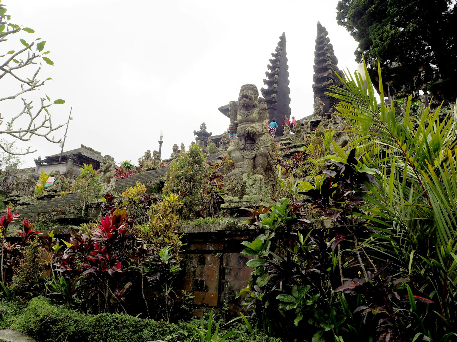 Landscape featuring sculptures and lush plants in a Balinese temple garden