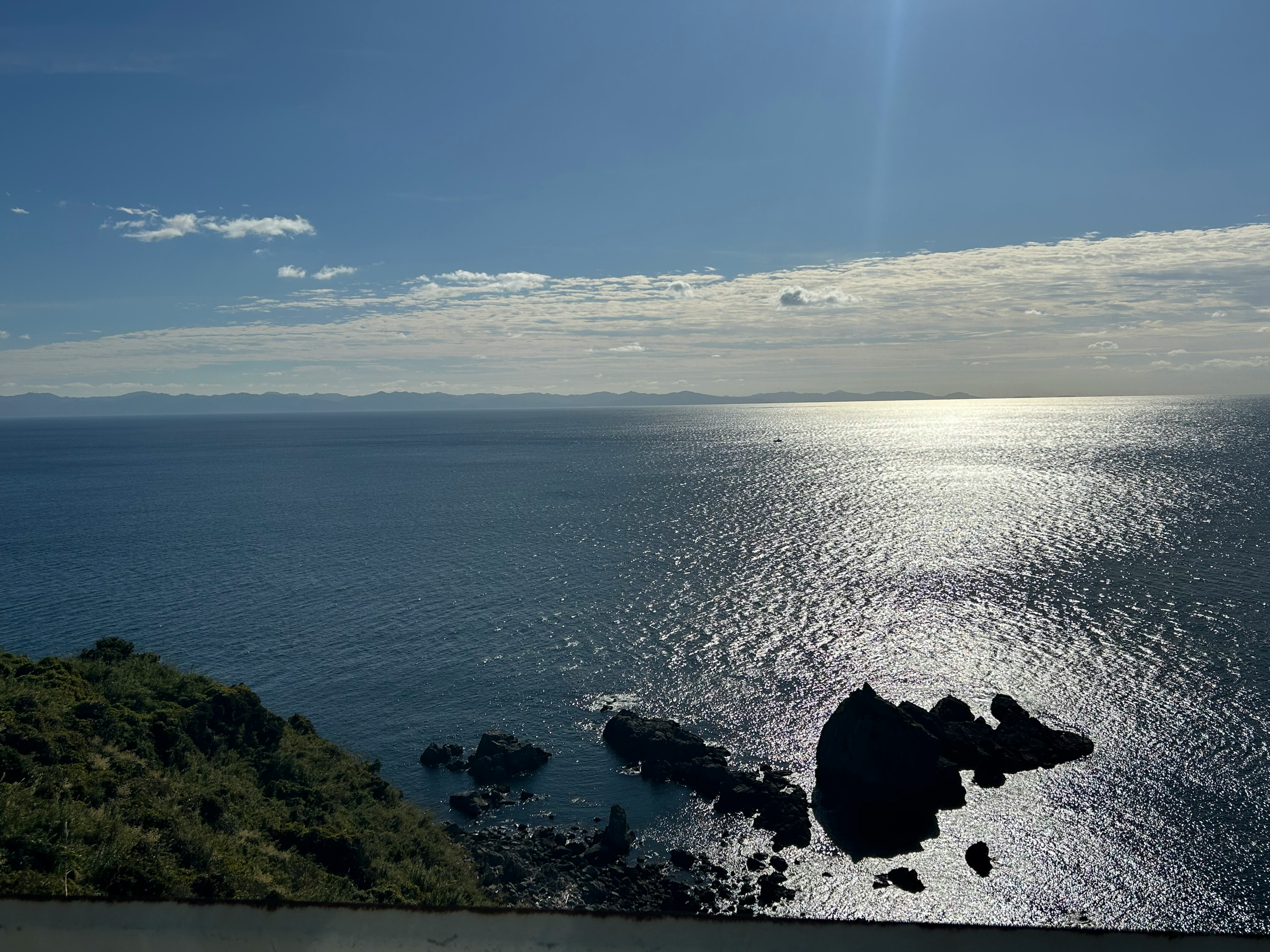 海に沈む夕日と岩礁のある海岸風景