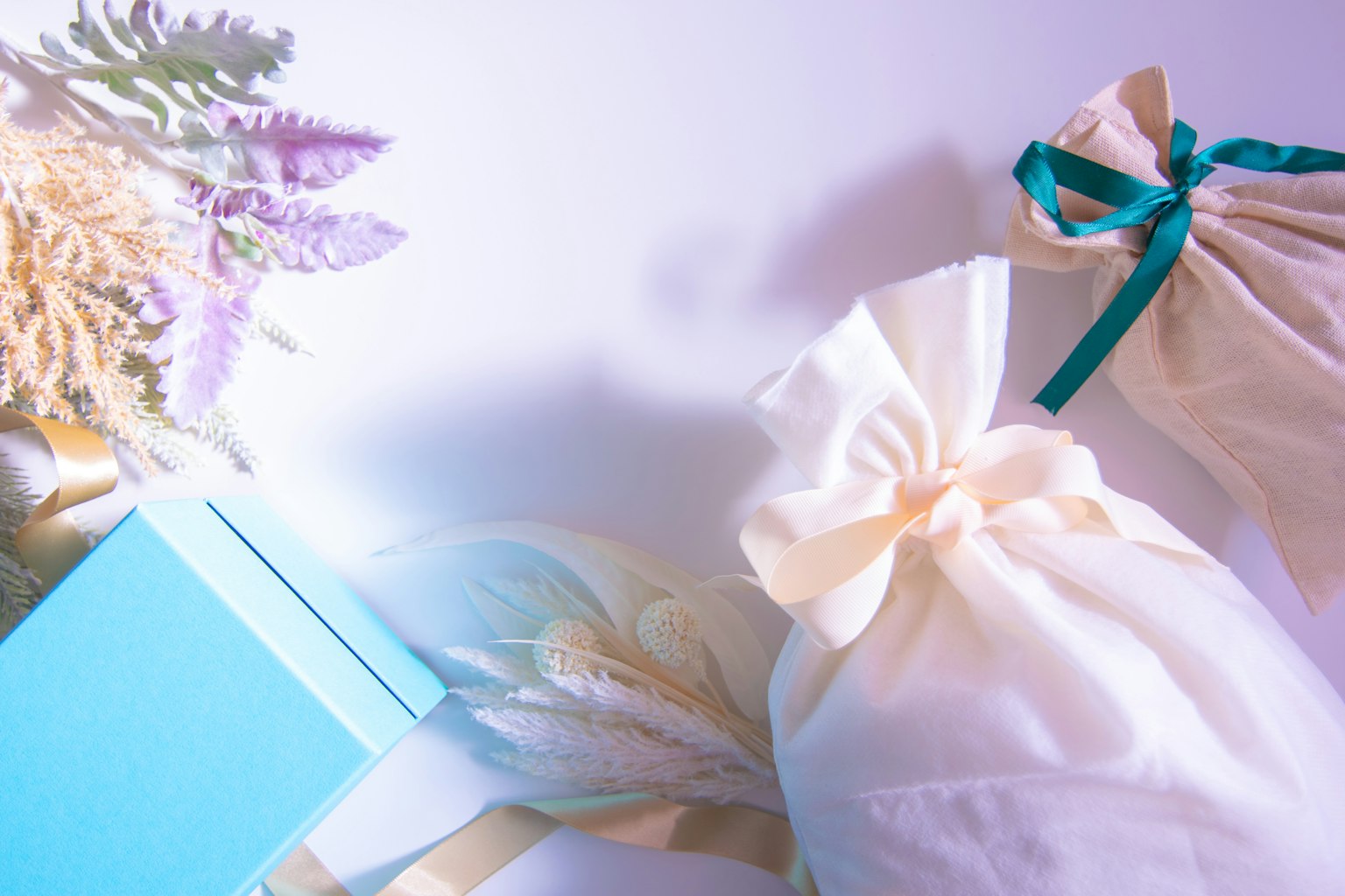 Un insieme di sacchetti regalo dai colori tenui e una scatola blu