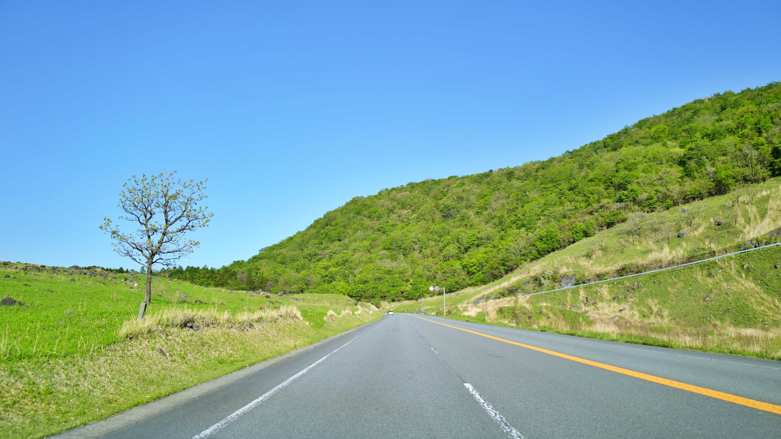 蓝天下绿丘的道路风景