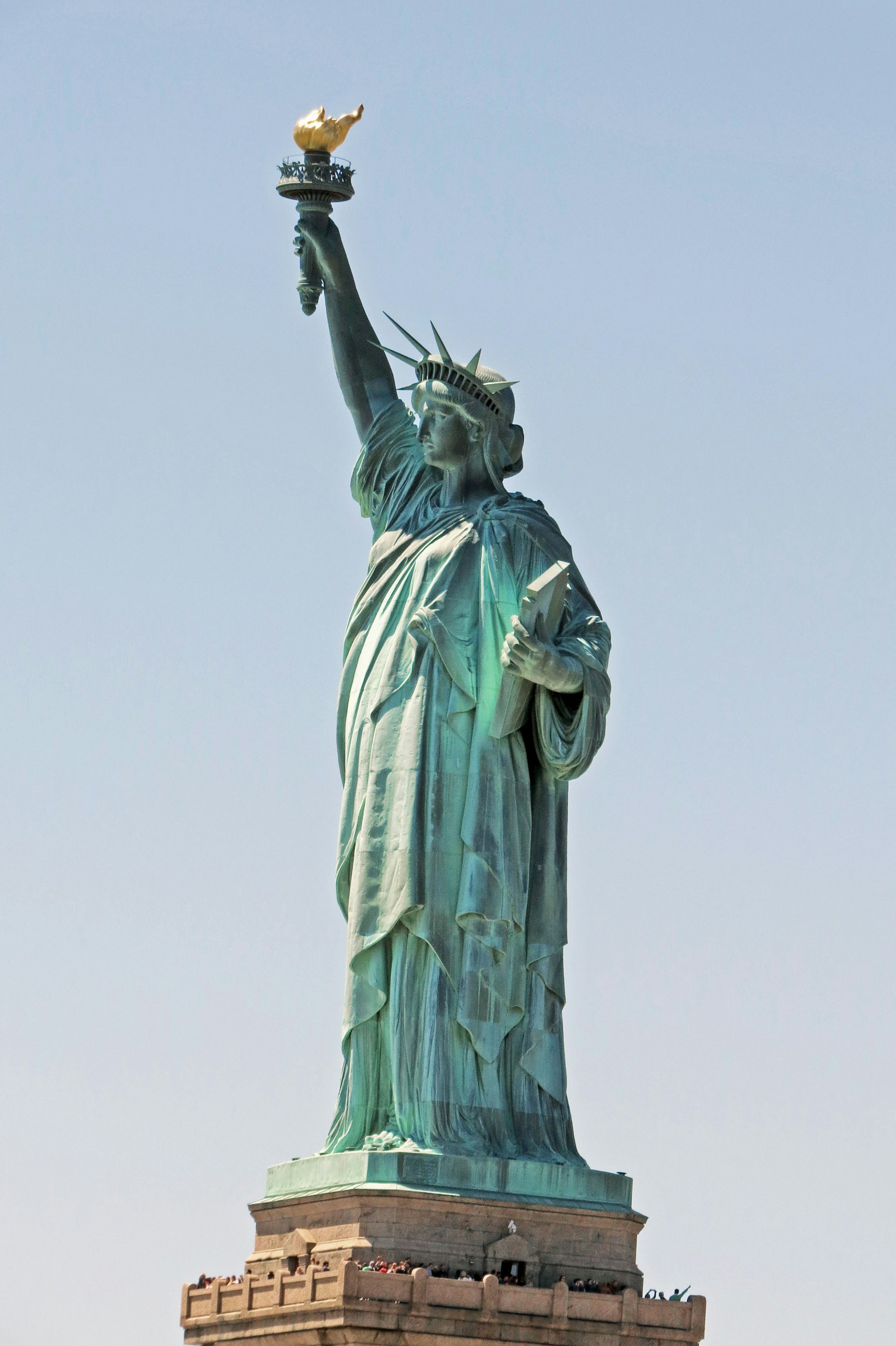 Statue of Liberty holding a torch with a clear sky background