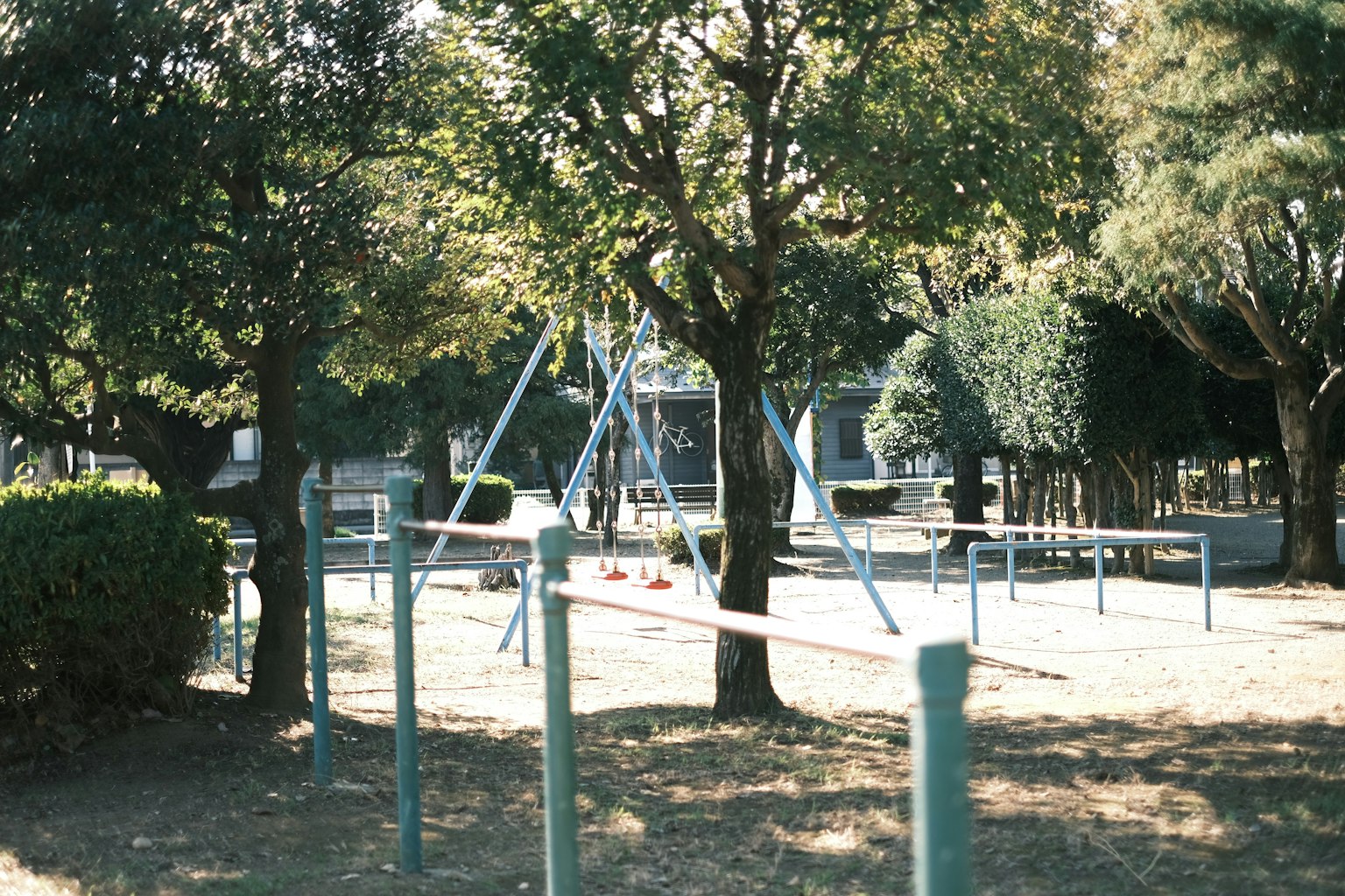 parco giochi con altalene e alberi circostanti