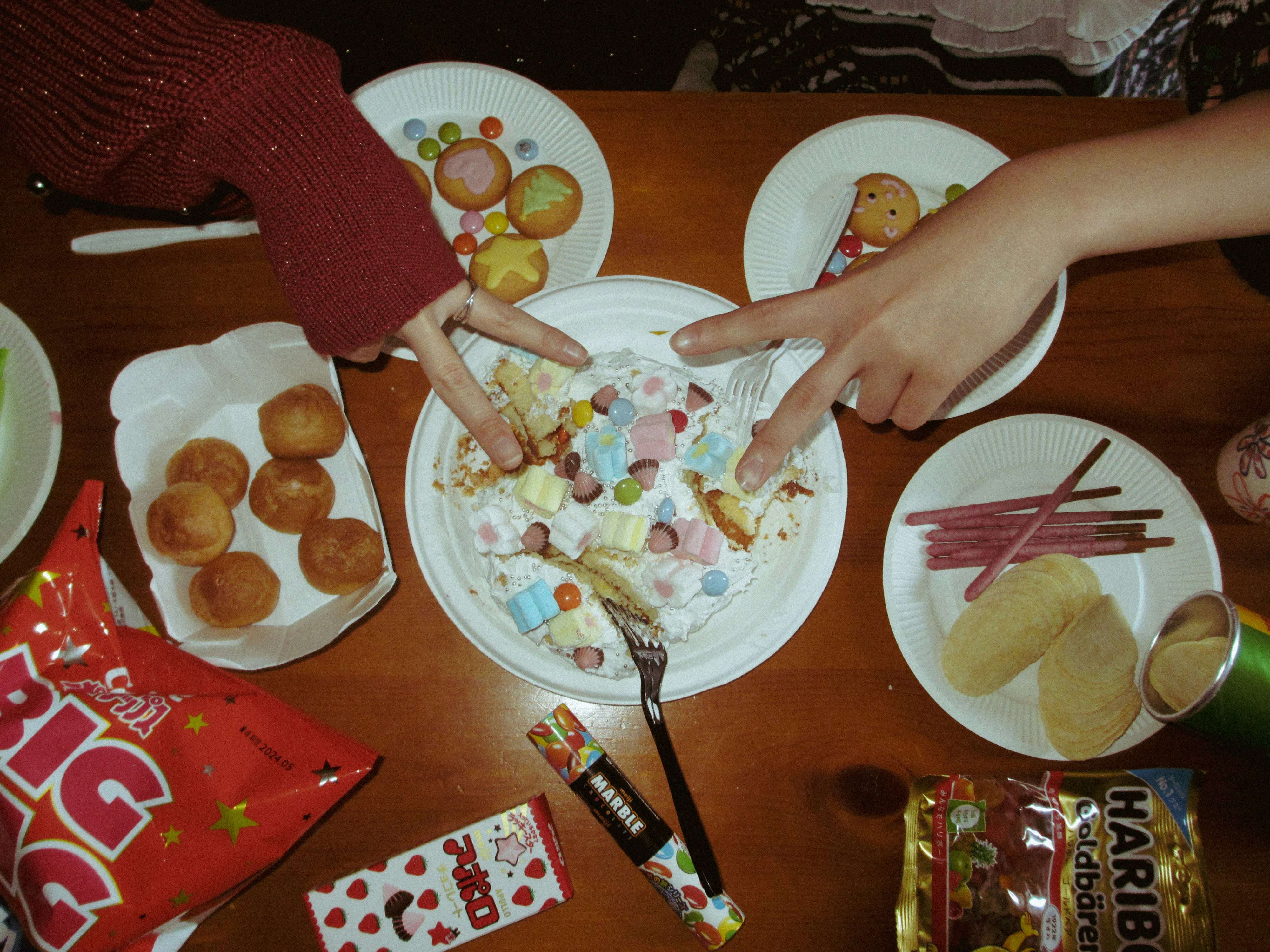 手作りのお菓子とプレートが並ぶ子ども向けパーティーの食卓