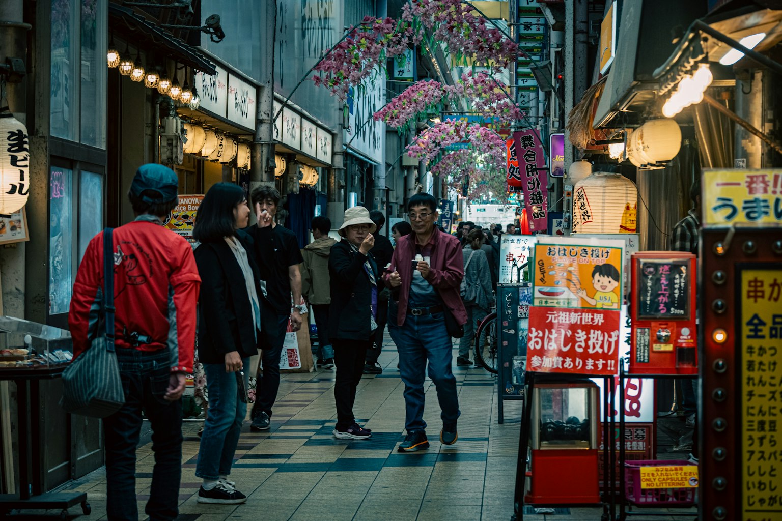 賑やかな日本の裏通りで人々が歩いている様子 色とりどりの花が飾られた通りの景観