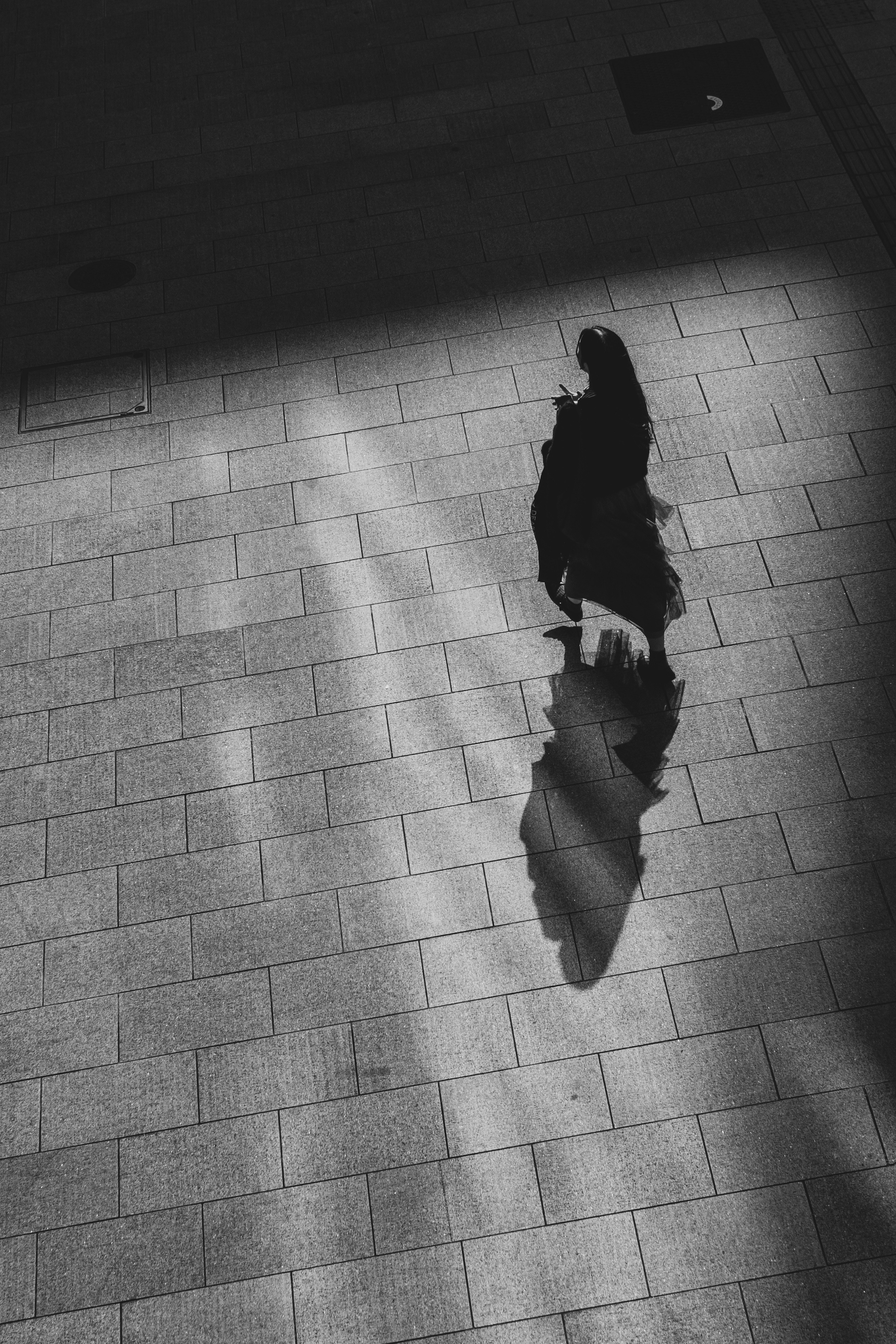 esquina de calle de noche con la sombra de una persona en el pavimento