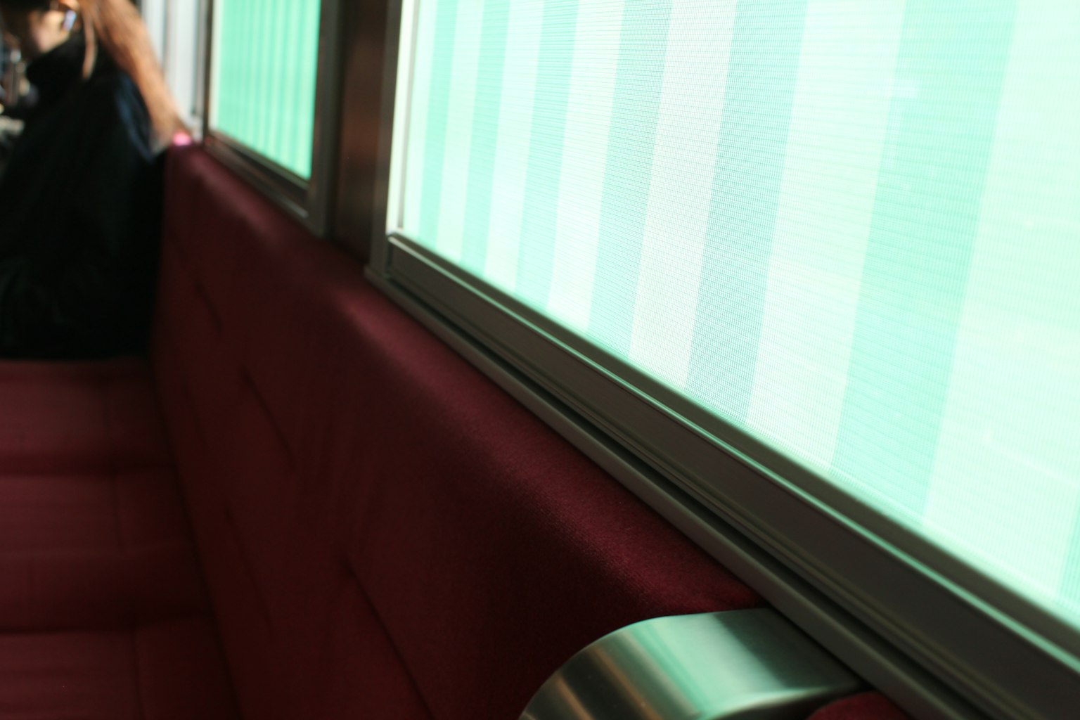 Interior of a cafe with red seating and green striped windows