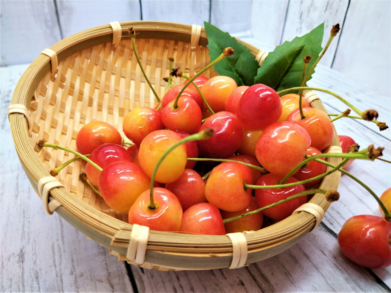 Una cesta llena de cerezas coloridas