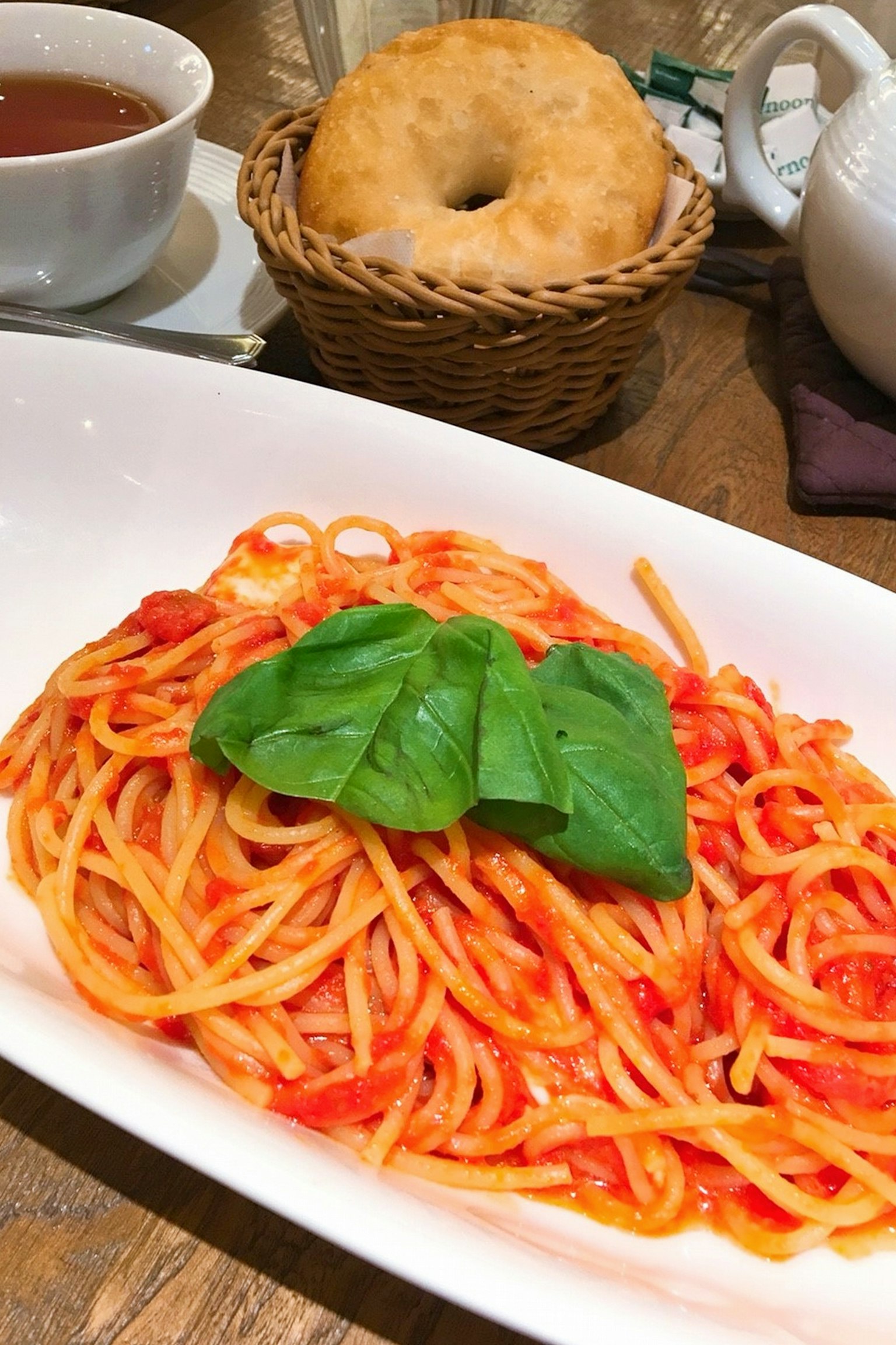 Spaghetti dengan saus tomat dan daun basil segar