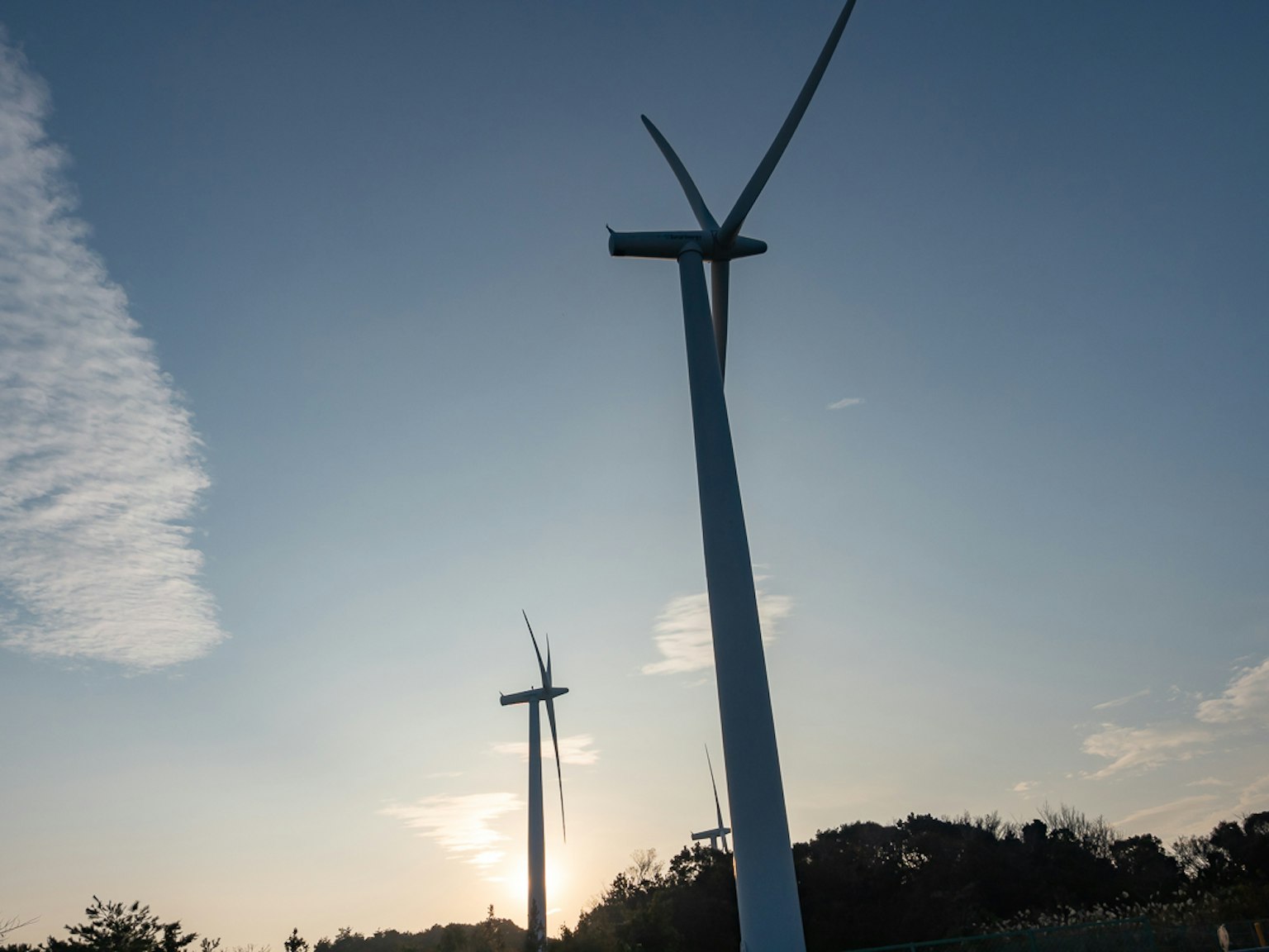 兩座風力發電機矗立在晴朗的藍天下