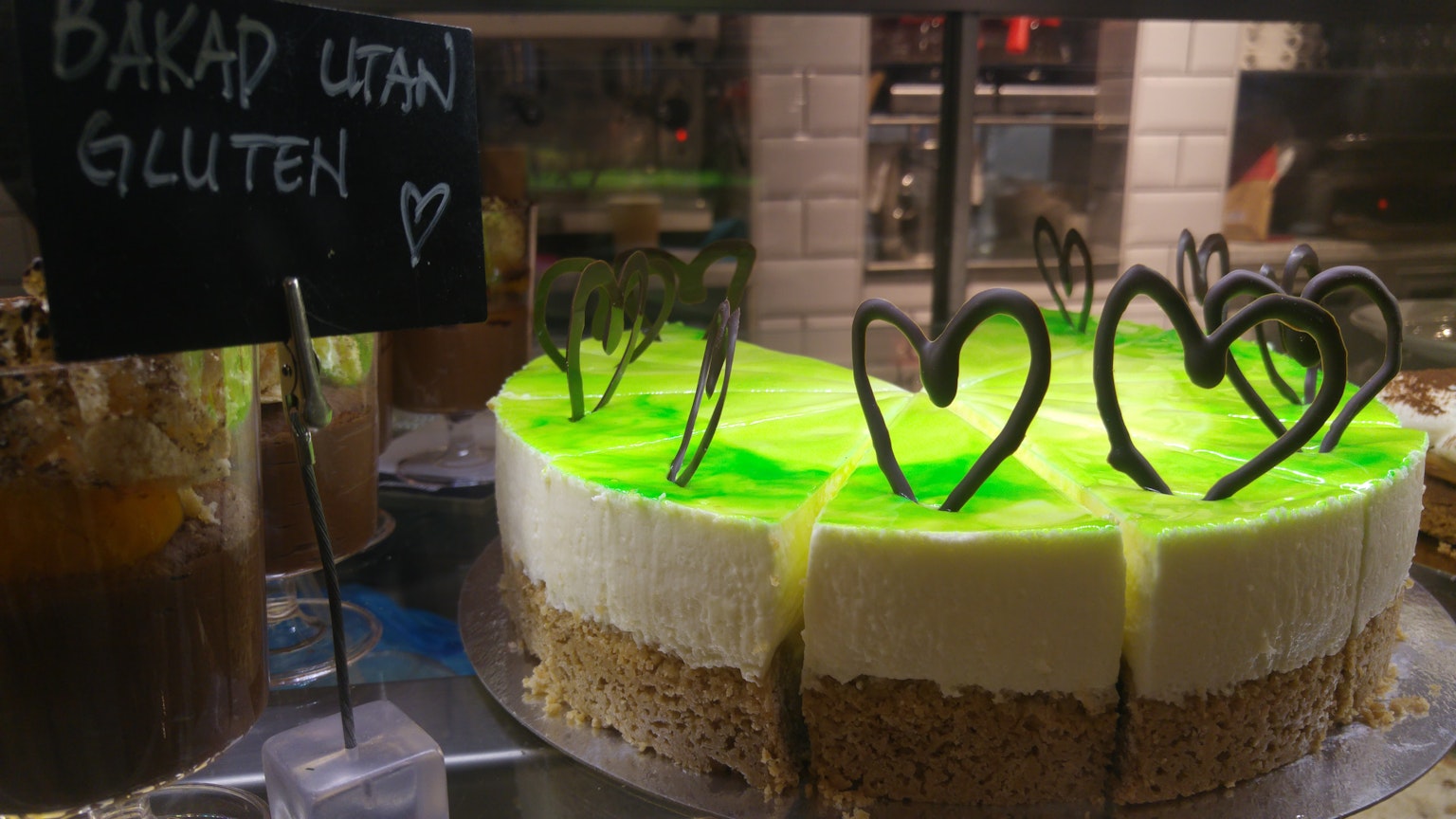 Gâteau en couches avec de la gelée verte et de la crème surmonté de décorations en chocolat en forme de cœur