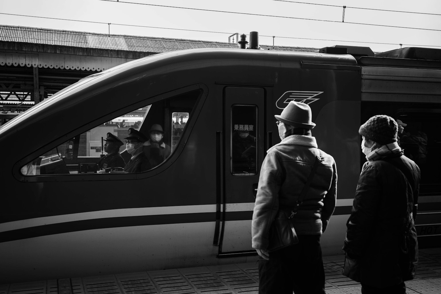 ฉากขาวดำของผู้คนสองคนที่มองรถไฟที่สถานี