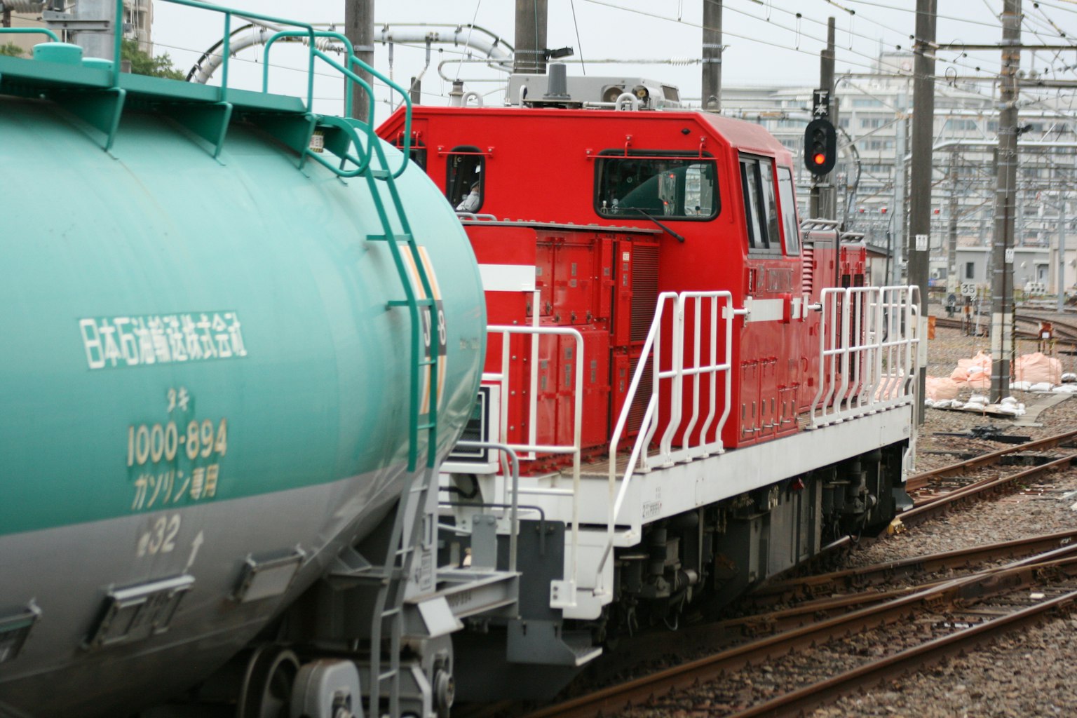 Rote Lokomotive mit grünem Güterwagen auf den Gleisen