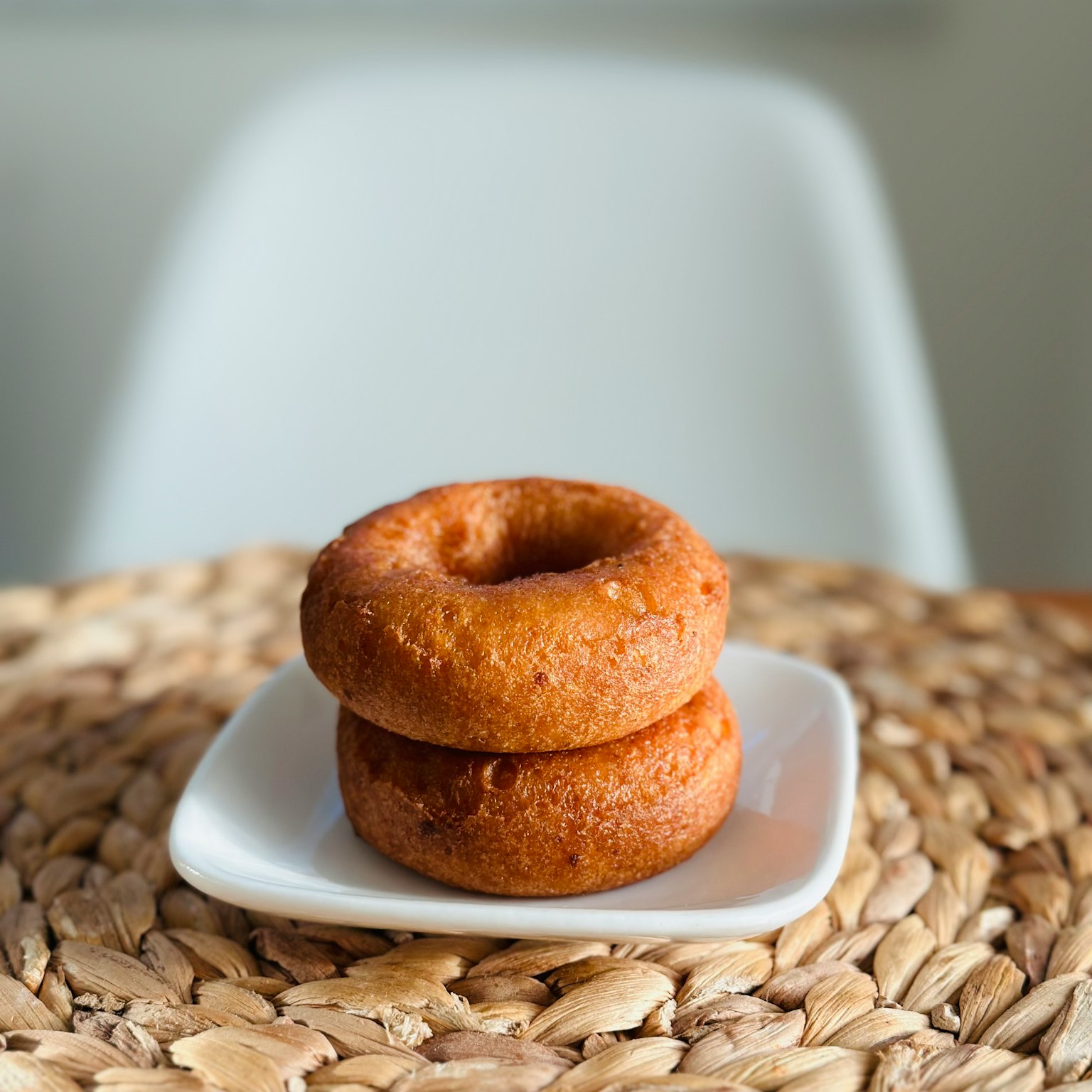 Zwei Donuts auf einem kleinen weißen Teller gestapelt