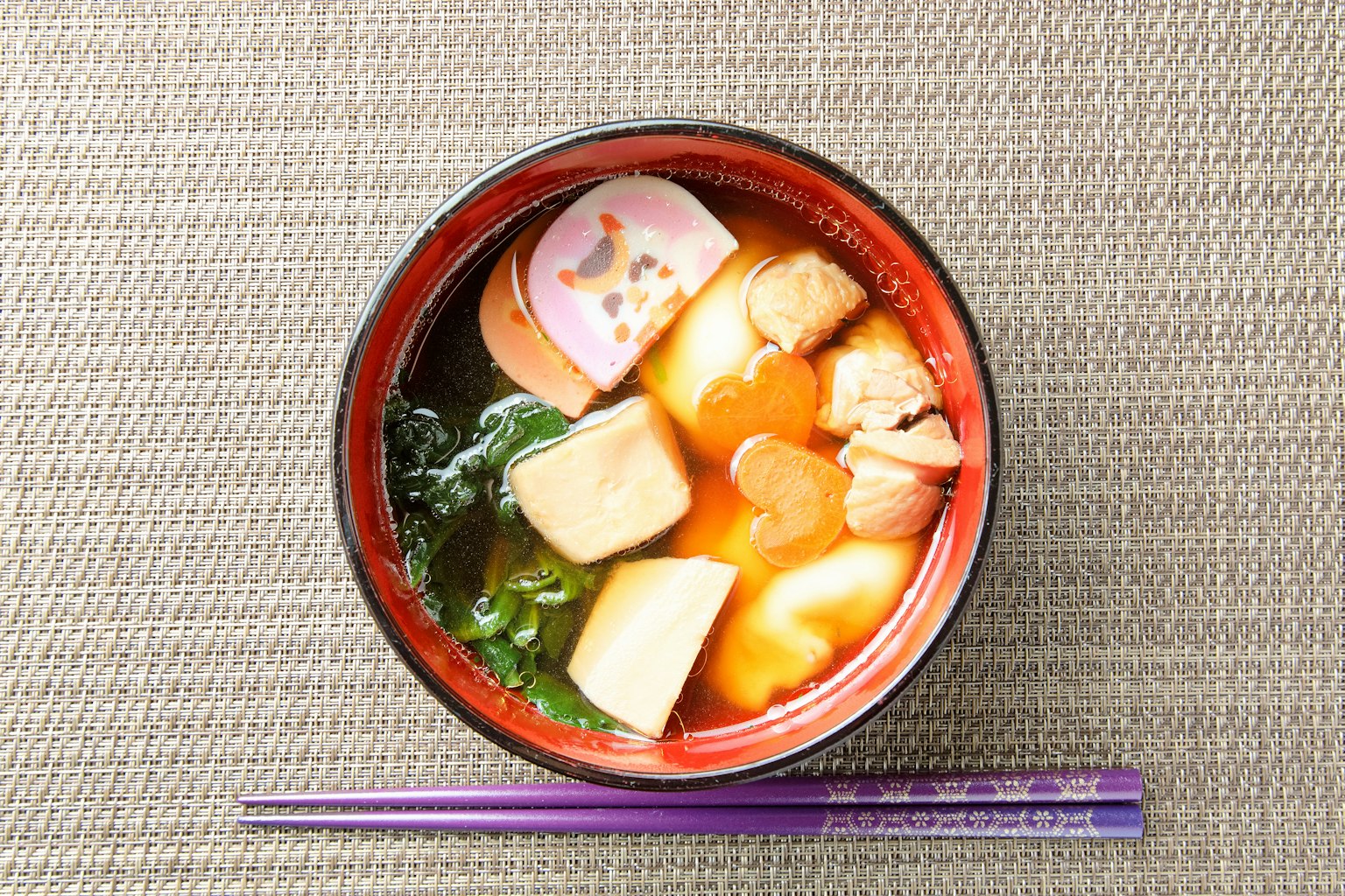 Mangkuk ozoni yang indah dengan ayam, mochi, sayuran, dan kamaboko