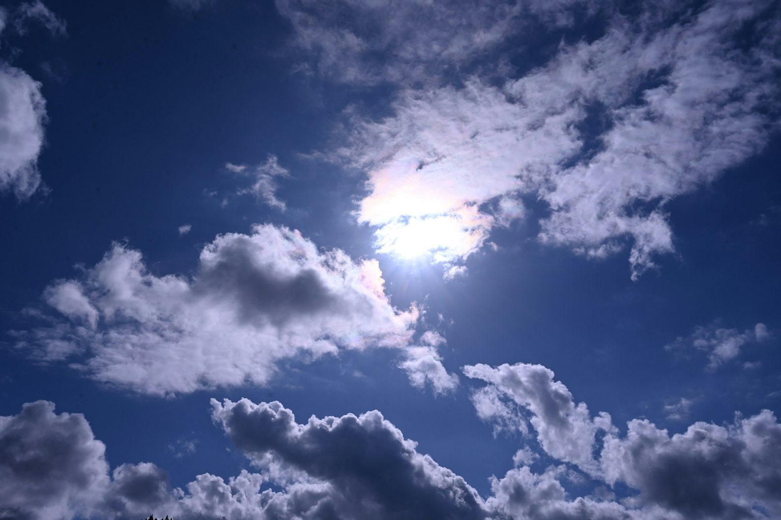 Luminosità del sole che si fa strada tra nuvole bianche soffici in un cielo blu