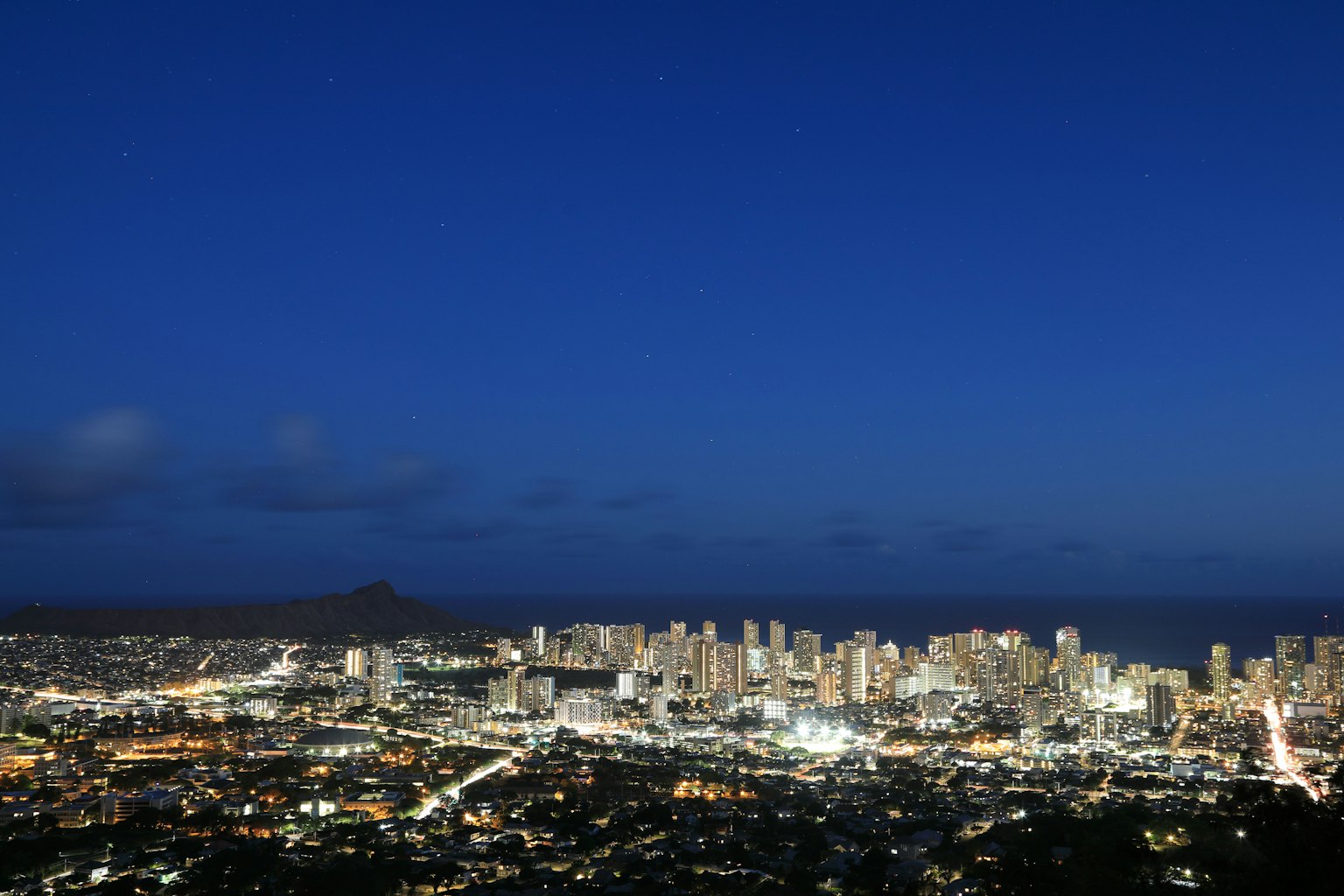 Paysage urbain nocturne avec des lumières de ville brillantes et un ciel bleu