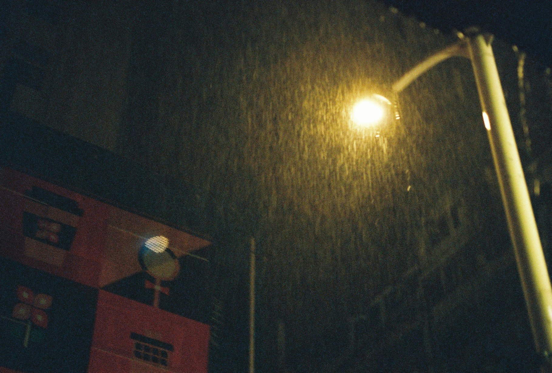 雨の夜の街灯と濡れた壁のある路地