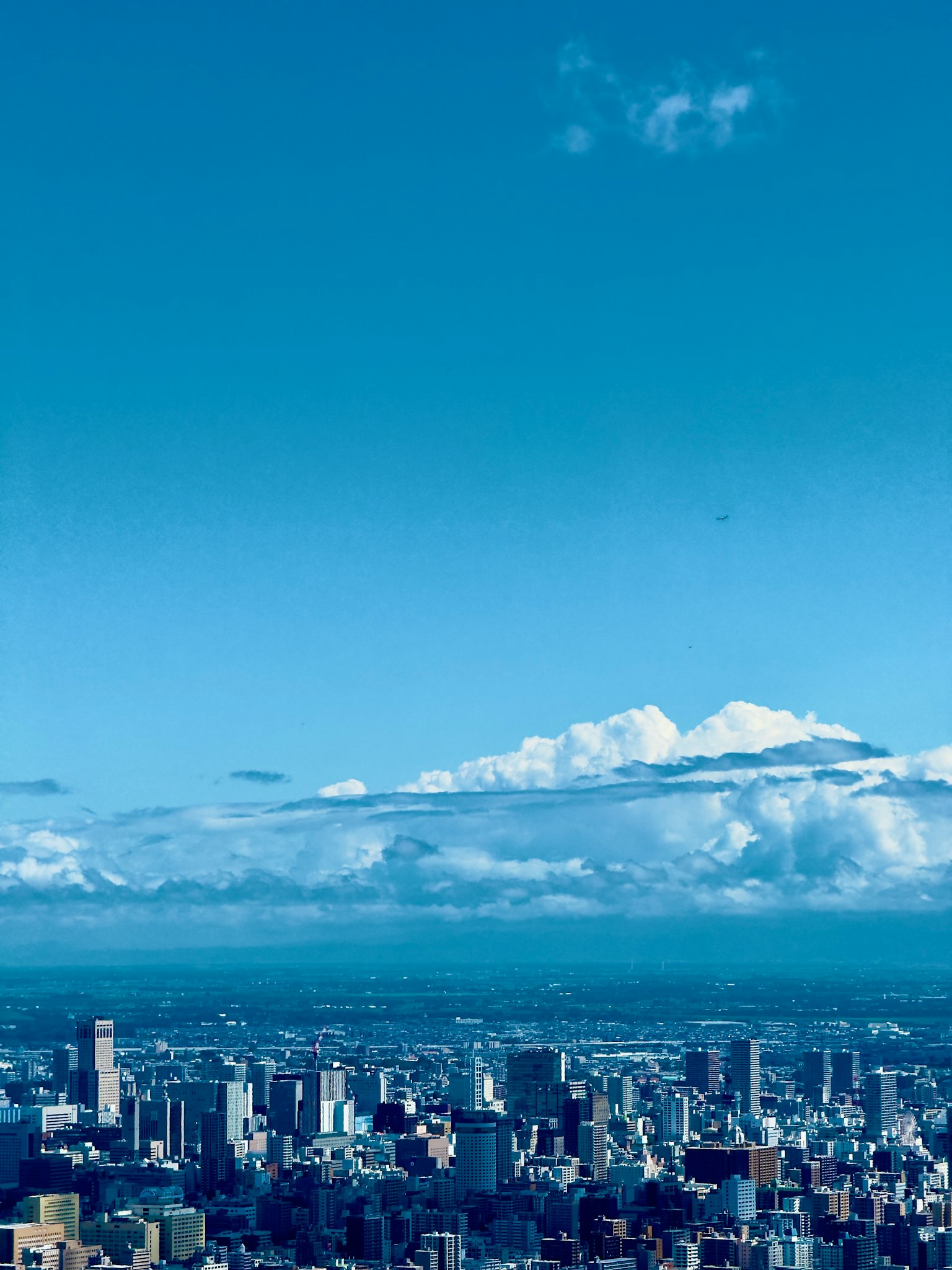 青い空と雲が広がる都市の風景