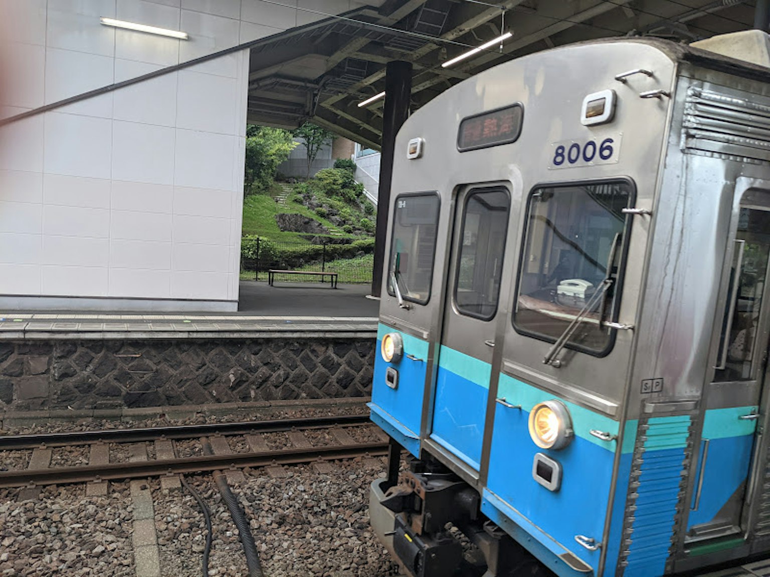 Treno argento con striscia blu in stazione