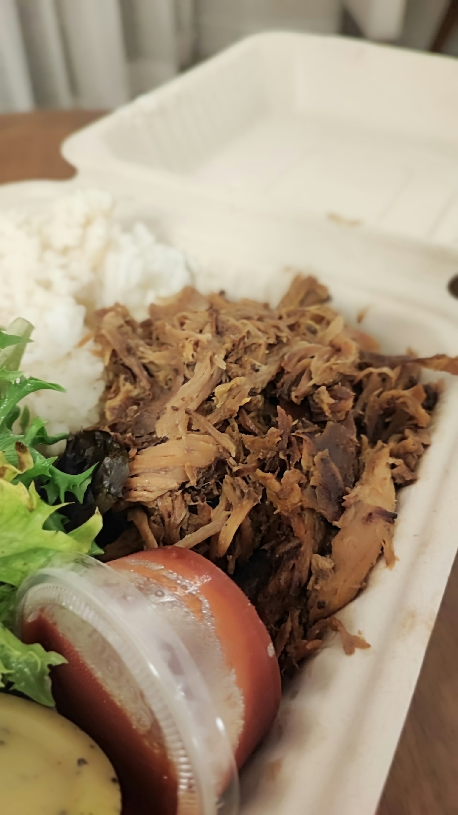 配有米饭和沙拉的撕碎肉菜肴的照片