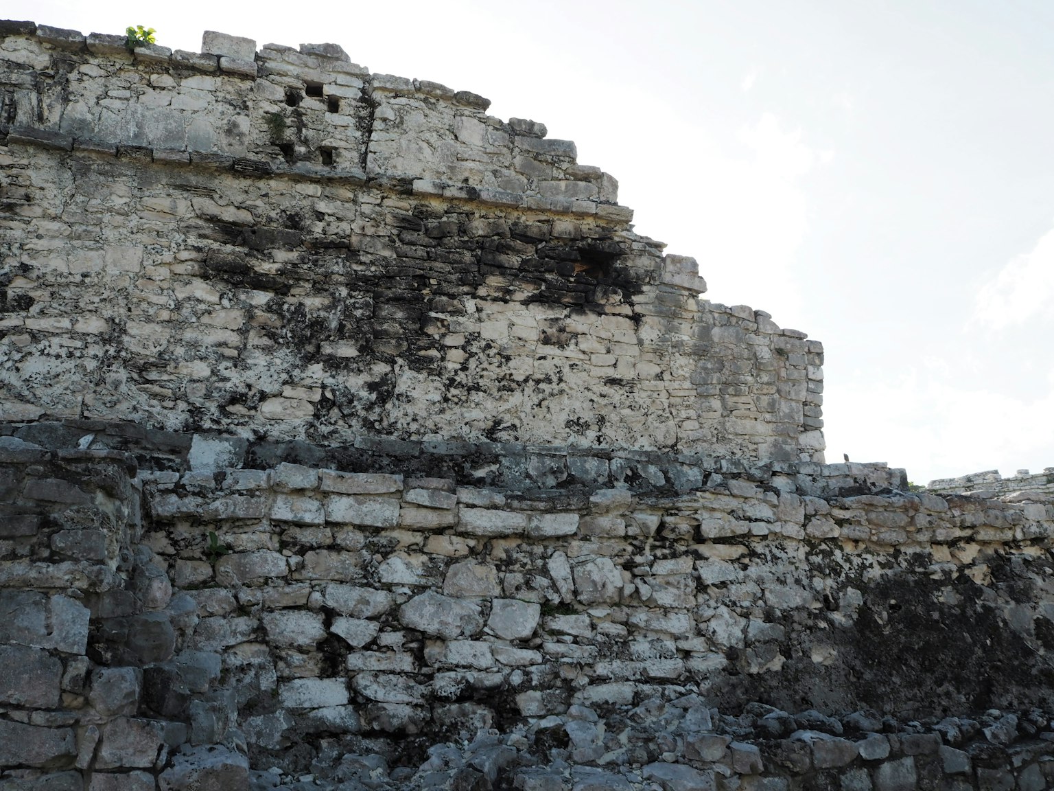 Image of ancient ruins showcasing weathered stone walls under a blue sky