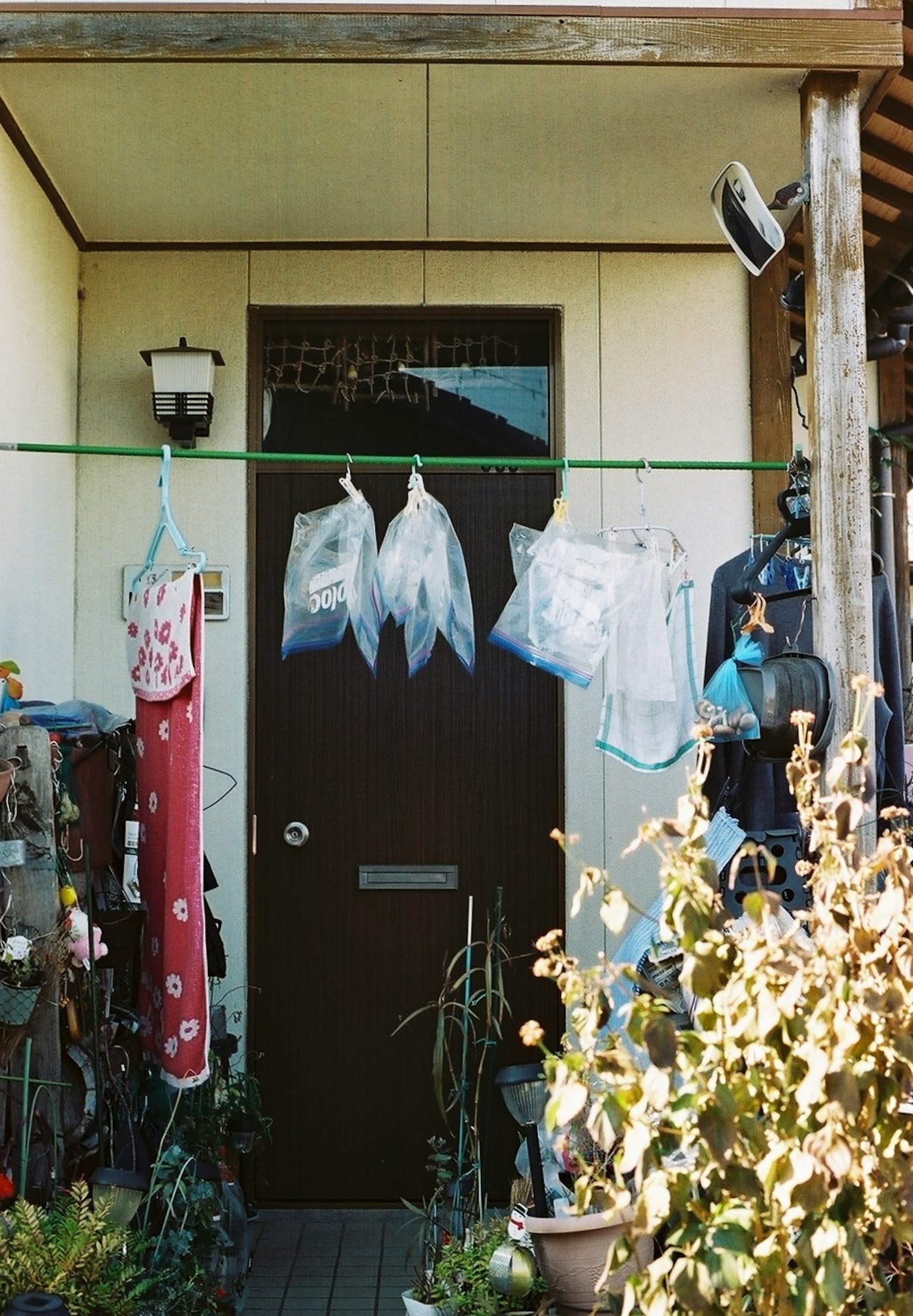 Une entrée de maison avec du linge suspendu devant une porte marron