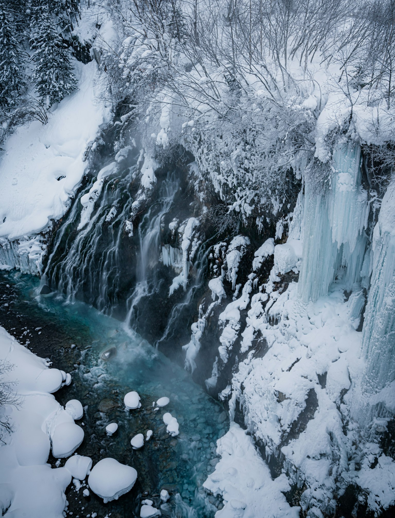 Paisaje invernal con una cascada cubierta de nieve y formaciones de hielo