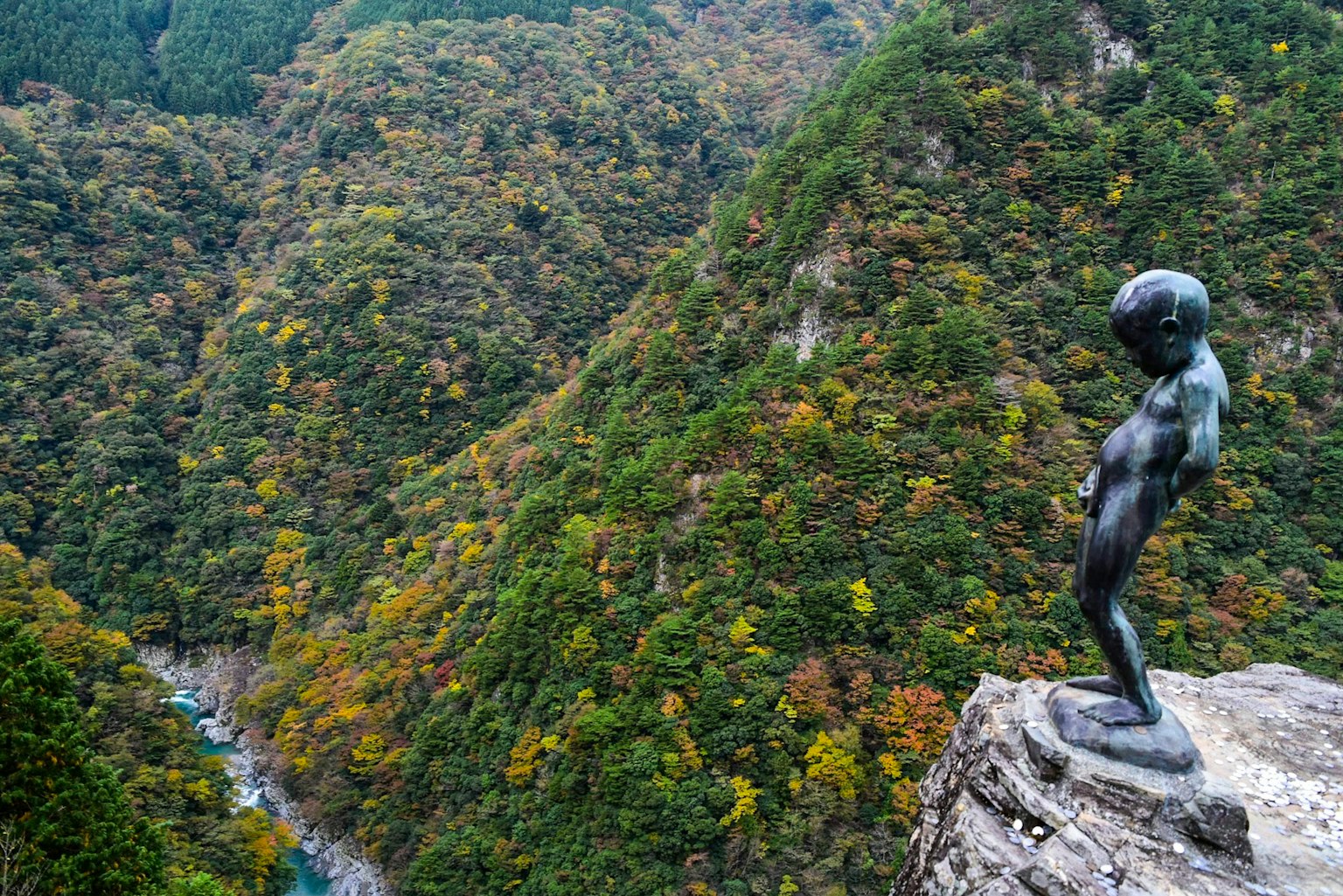 경치 좋은 산악 풍경을 내려다보는 작은 청동 조각상