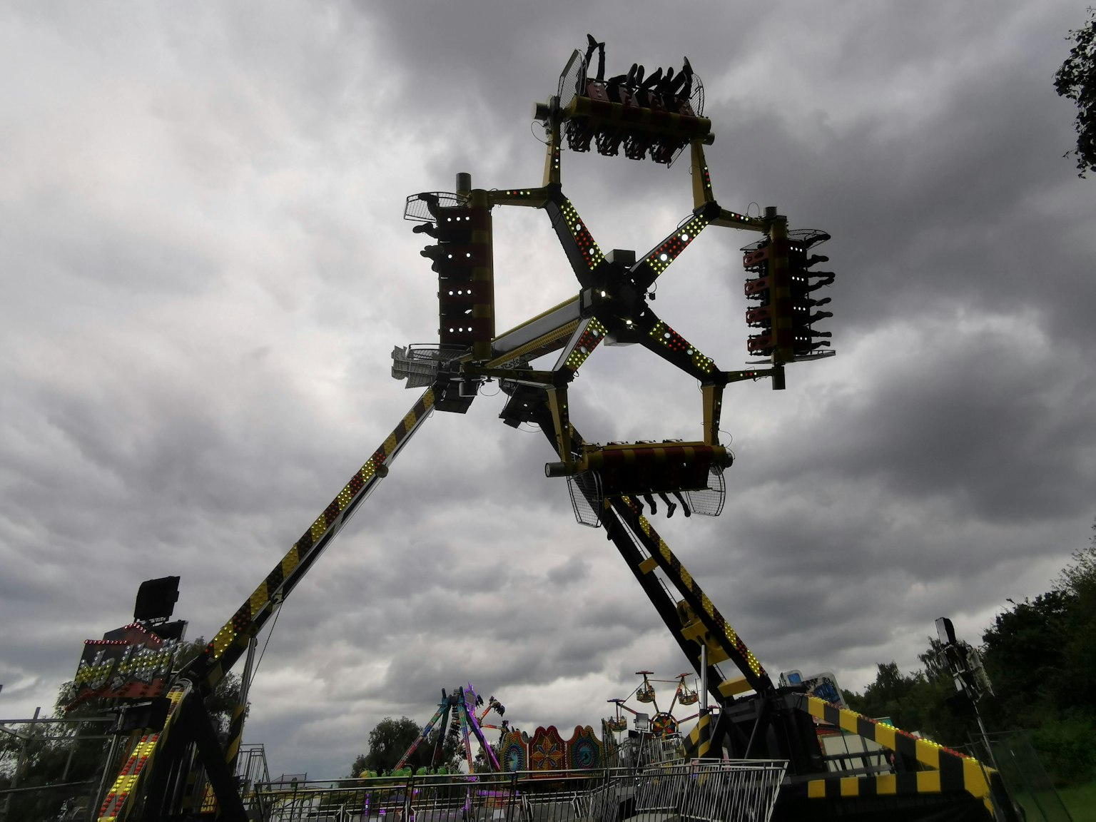Atracción emocionante en un parque de diversiones bajo nubes grises