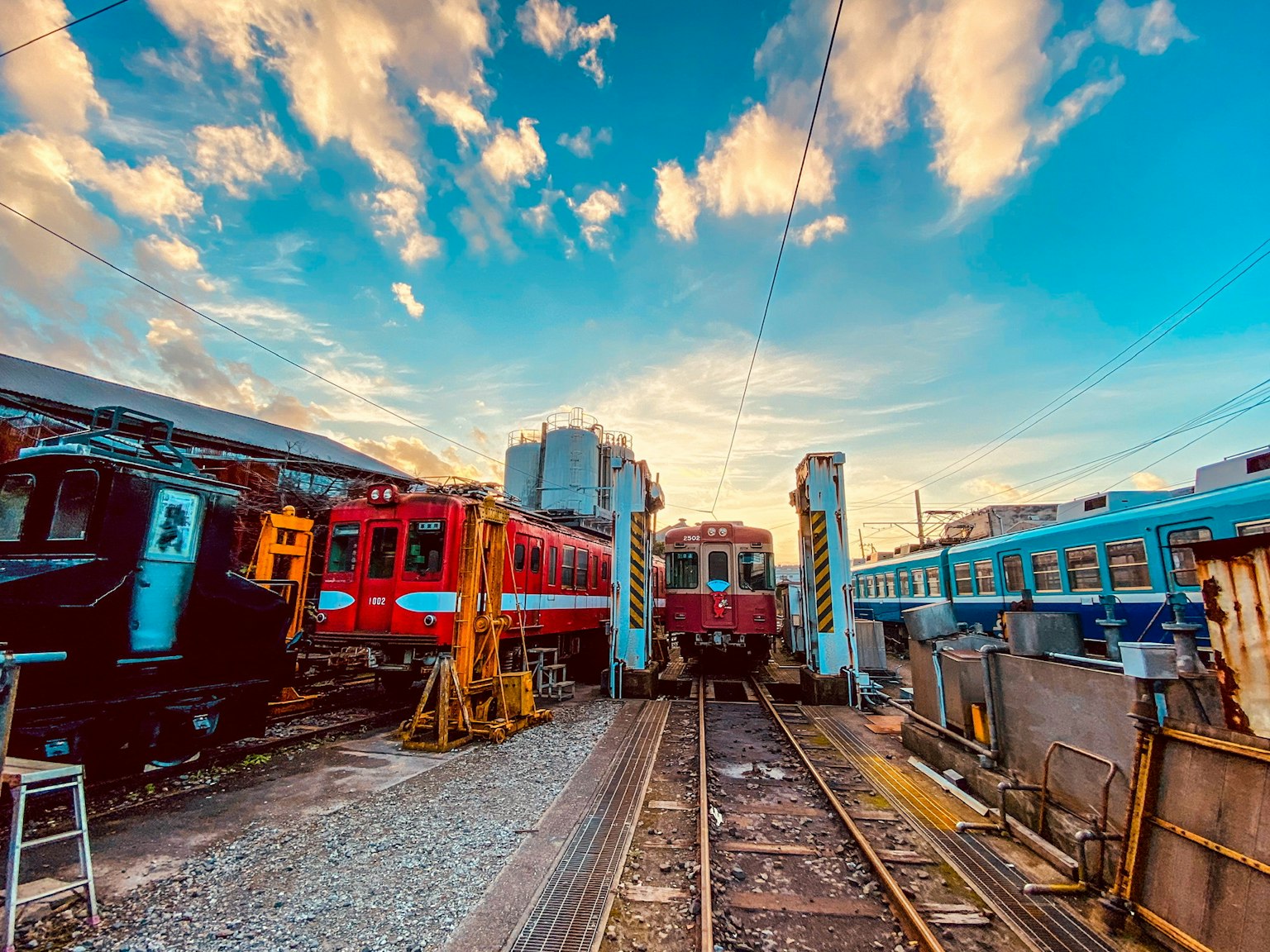 Scène ferroviaire colorée avec des trains sous un ciel de coucher de soleil