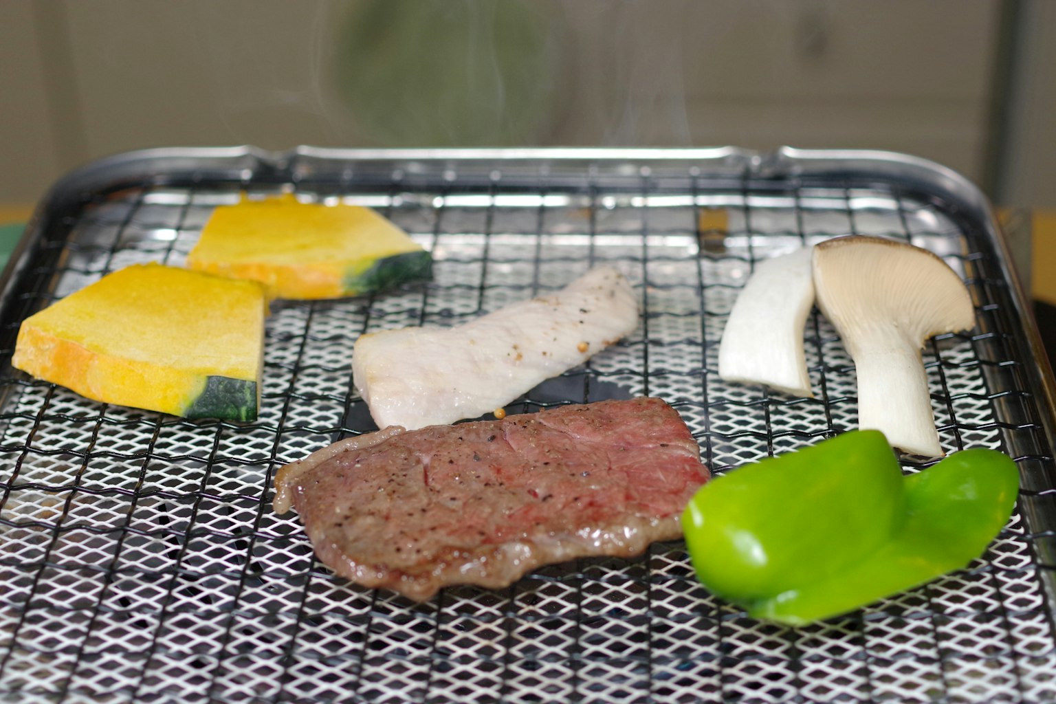 Assorted vegetables and meat grilling on a barbecue