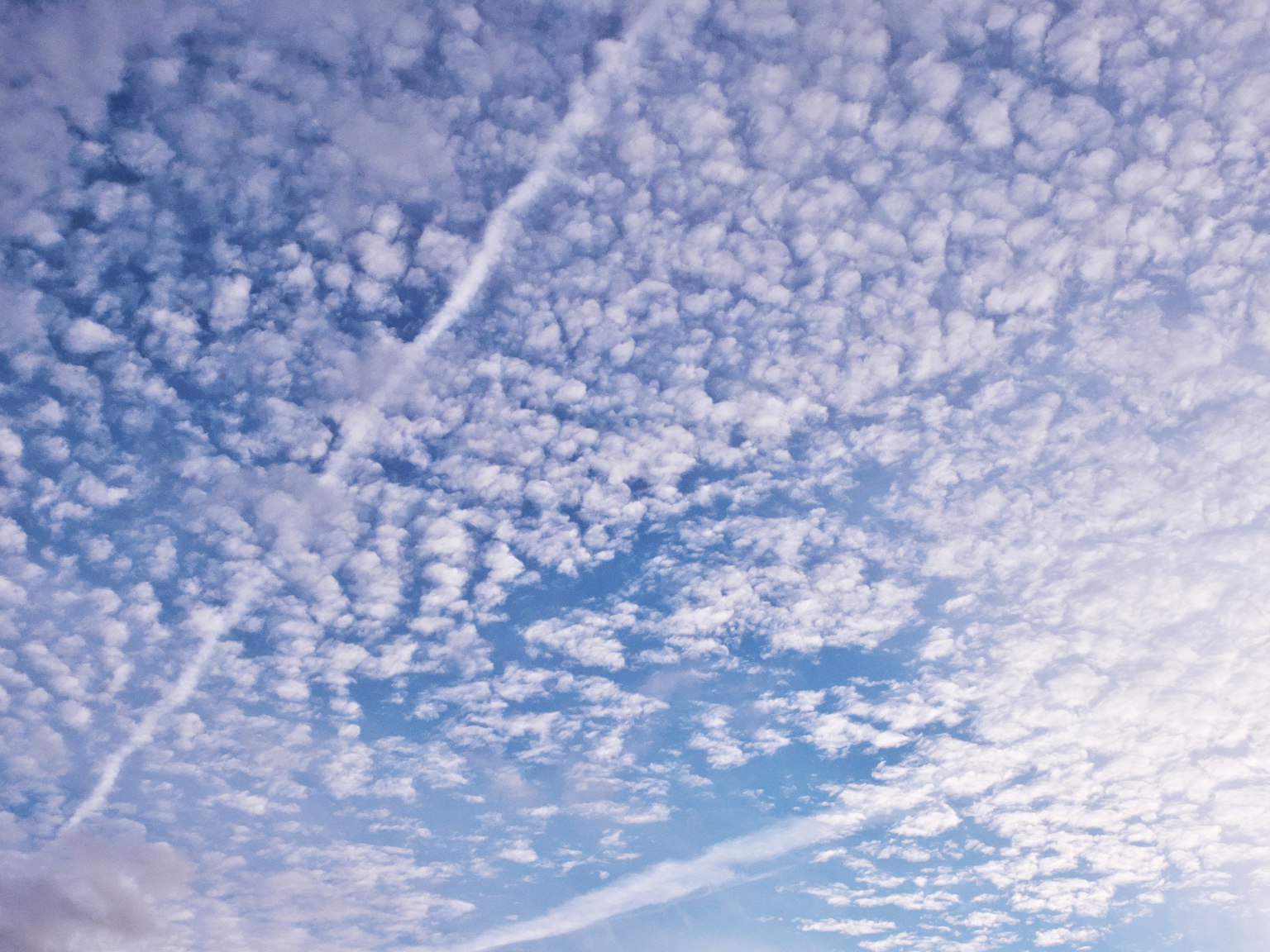 Ein weitläufiger Himmel voller weißer Wolken und blauer Töne