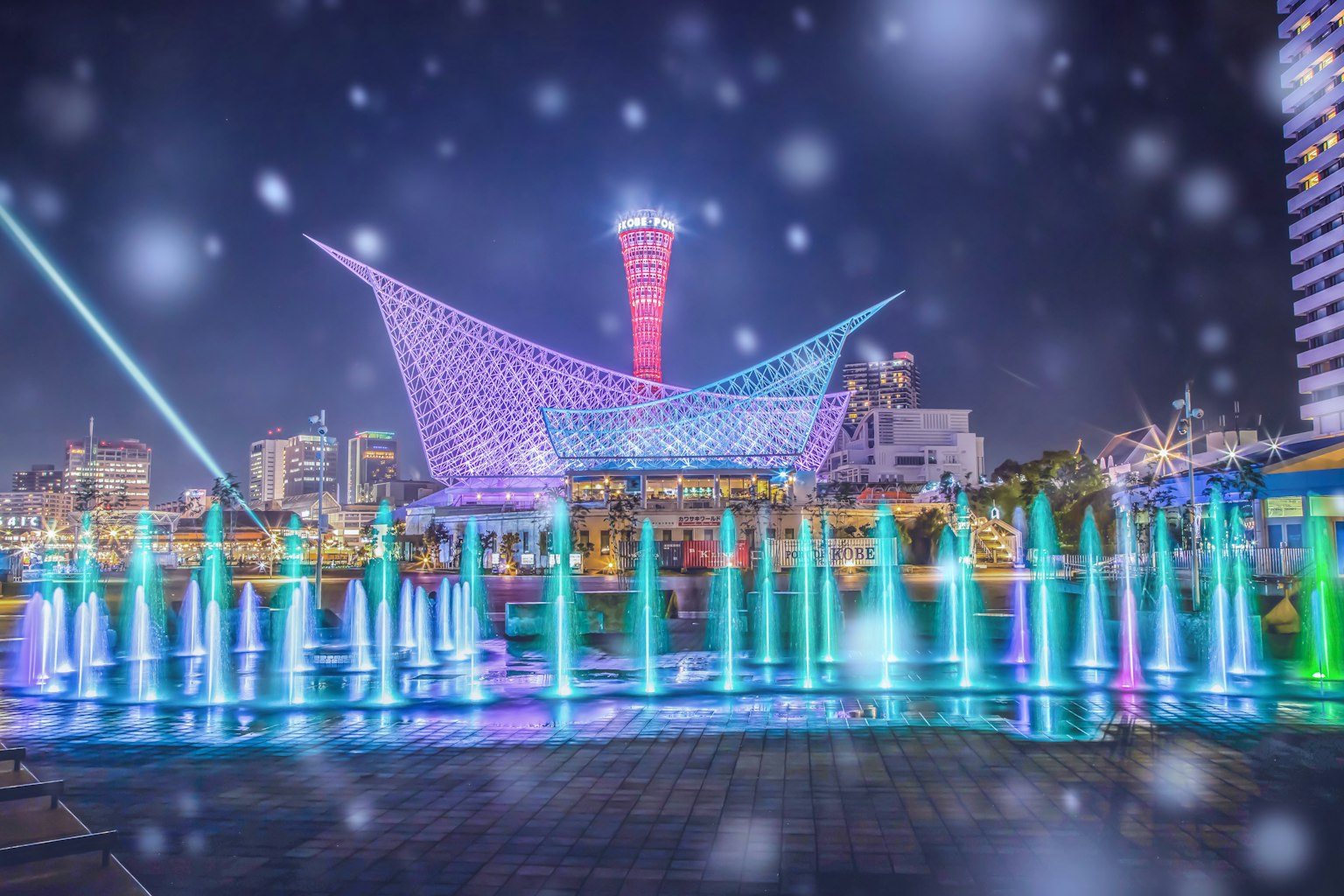 Fontane colorate e architettura moderna illuminate di notte a Kobe