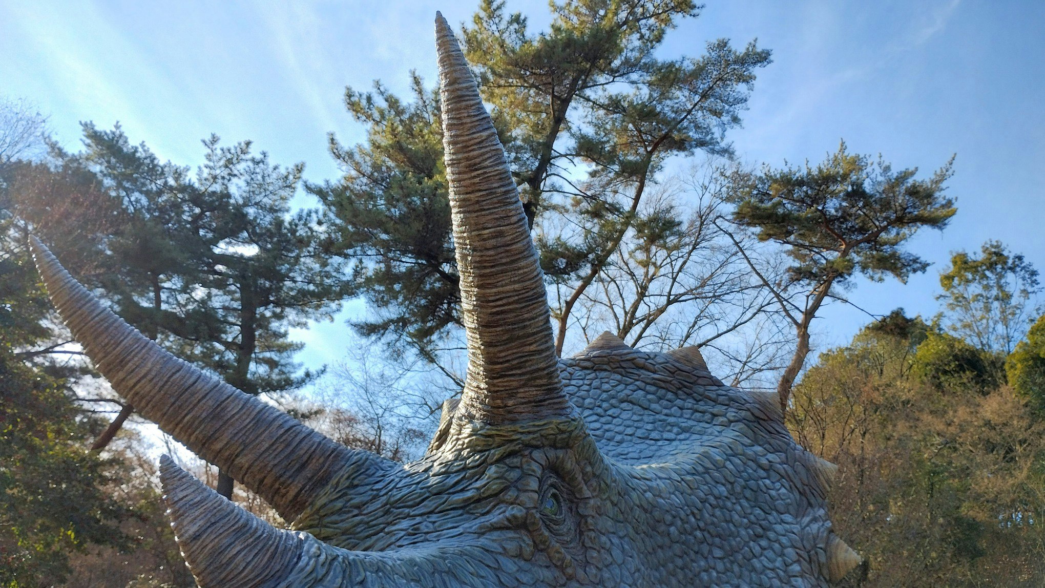 恐竜の背中と翼のある巨大なフィギュアのある屋外風景