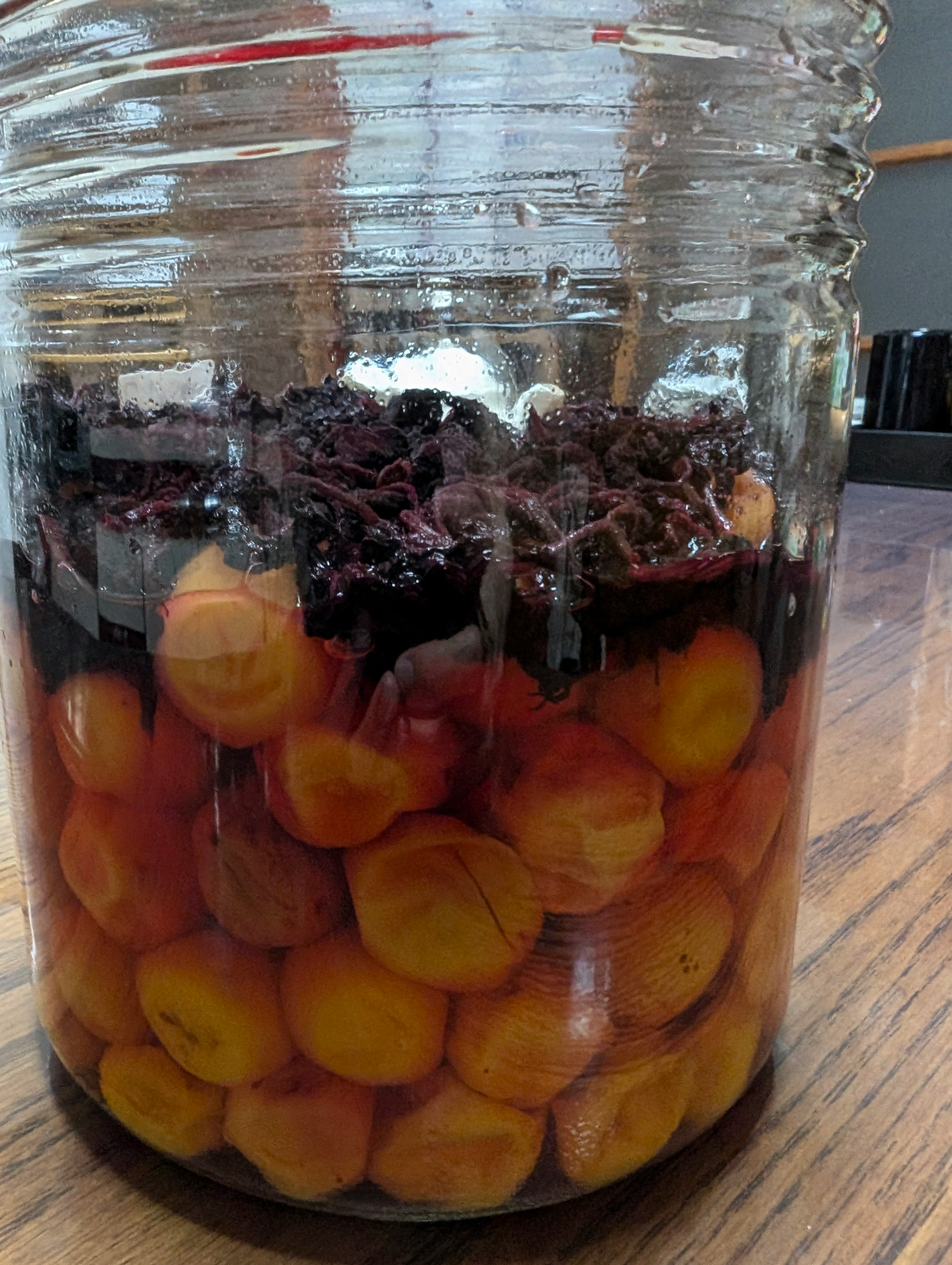 jar filled with red berries and yellow fruit dessert
