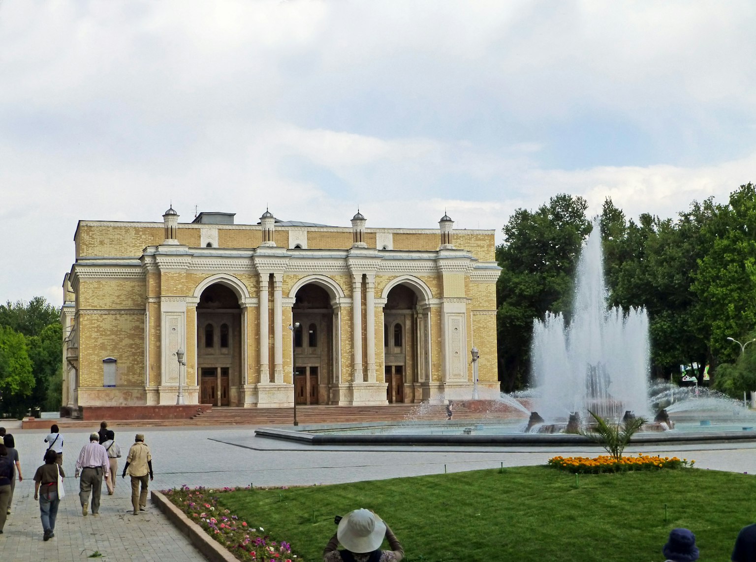 Blick auf einen Park mit Brunnen und historischem Gebäude