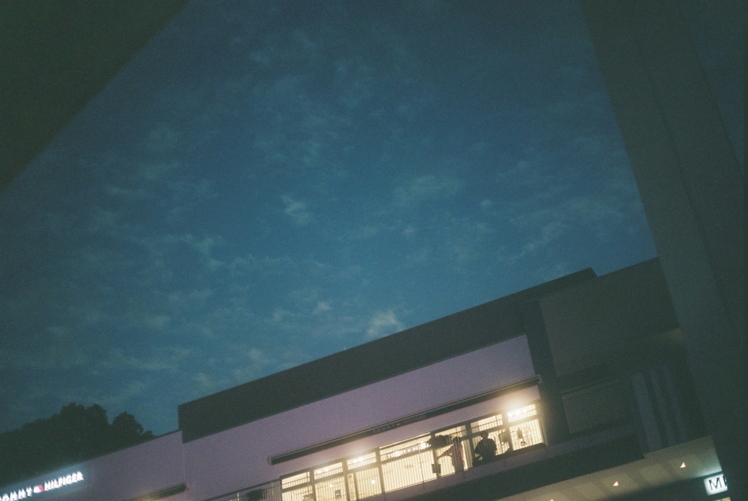 Ciel nocturne avec des nuages et fenêtres d'un bâtiment illuminé