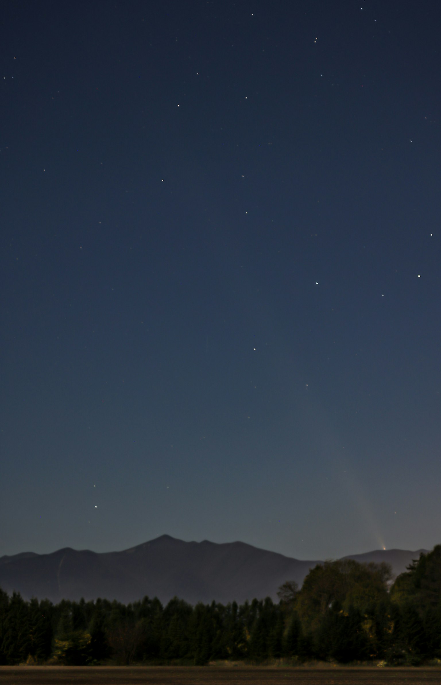 Nachthimmel mit verstreuten Sternen und Silhouette von Bergen