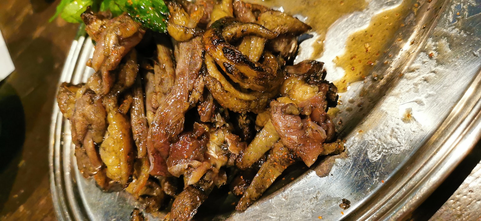 Carne alla griglia servita su un piatto d'argento con verdure